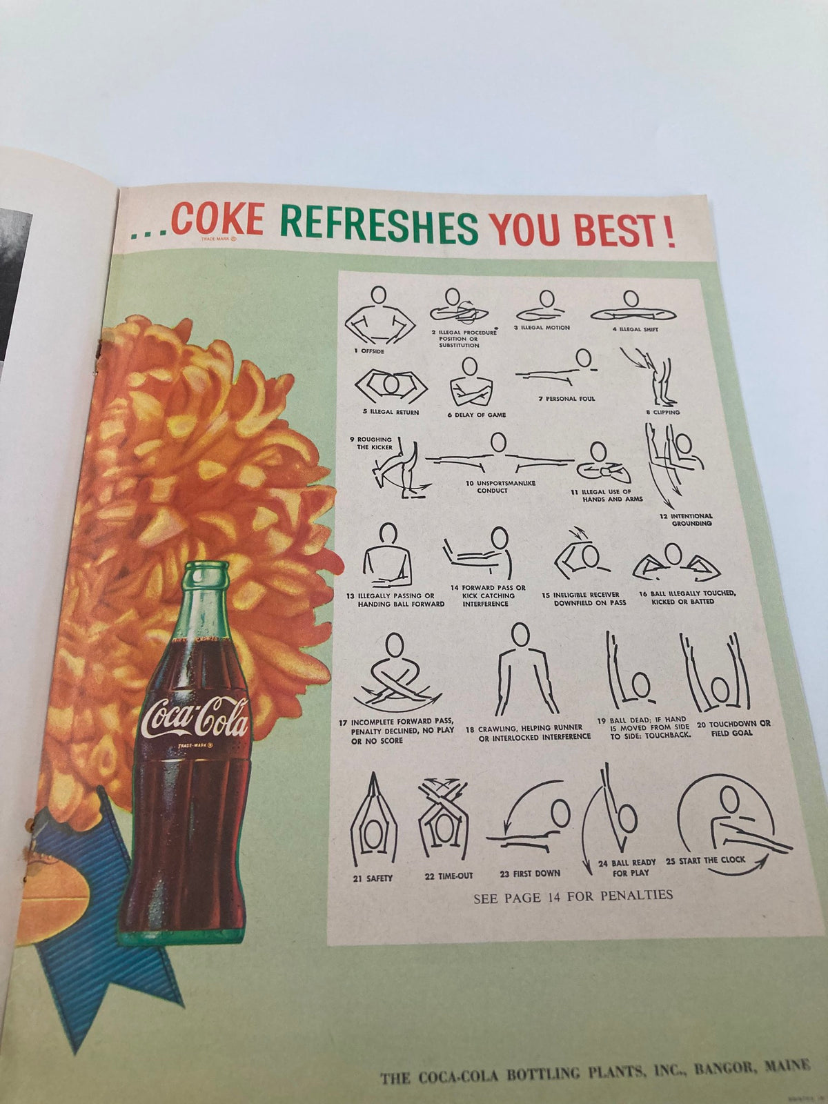 Inside page from the October 8 1960 Football Maine New Hampshire Homecoming Souvenir Official Program displaying a Coca-Cola advertisement with penalty signals.
