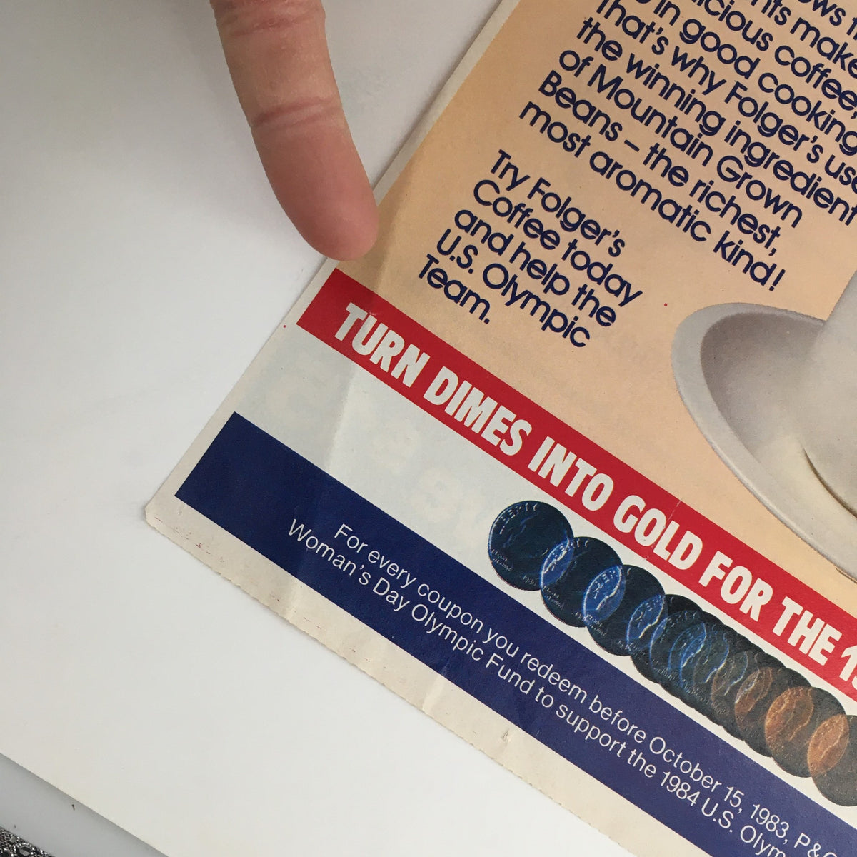 Close-up detail of the 1983 Mountain Grown Folger's Coffee Olympic Team Circular Coupon Advertisement, highlighting the promotional message about turning dimes into gold for the 1984 U.S. Olympic Team.