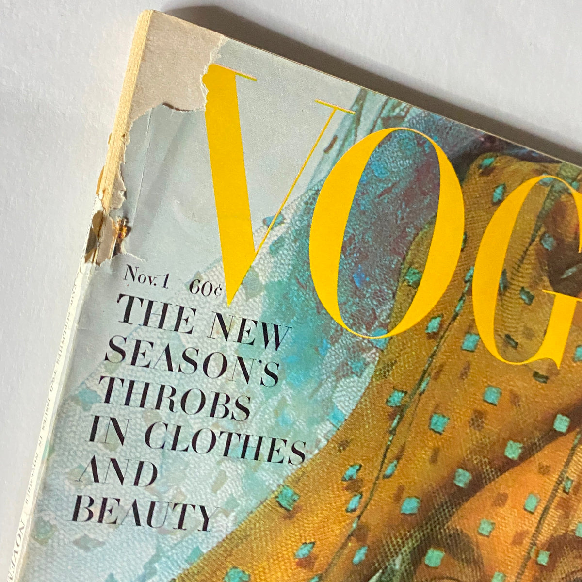 Close-up of the VTG Vogue Magazine November 1, 1962, showcasing the cover details with the headline 'THE NEW SEASONS THROBS IN CLOTHES AND BEAUTY' and its iconic title.