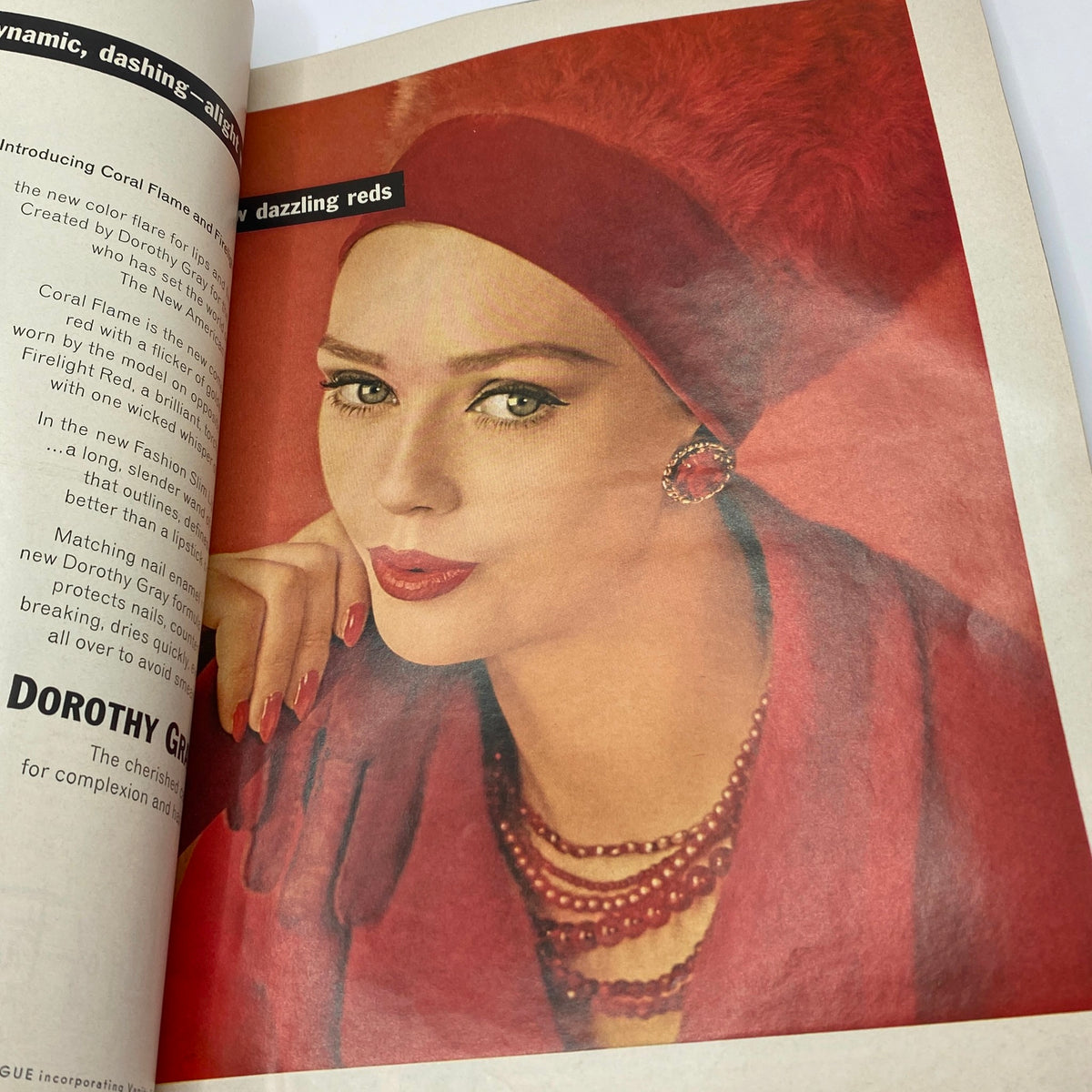 A glamorous model in VTG Vogue Magazine September 15 1962, showcasing dazzling reds with a stylish outfit and accessories, representing the fashion trends of the early '60s.
