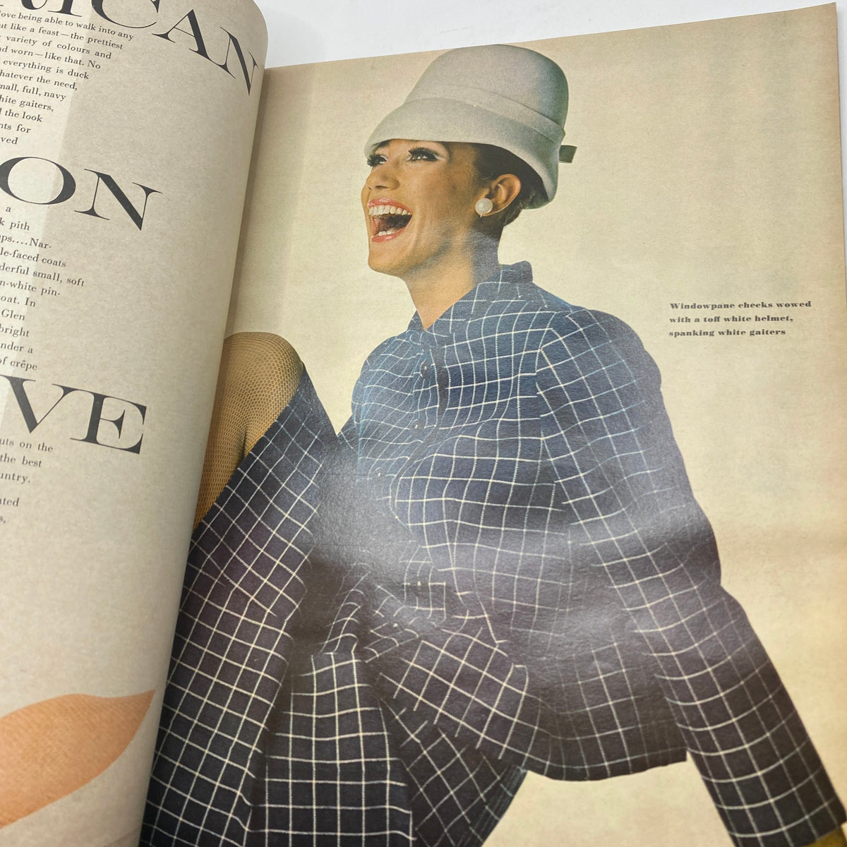 Candid fashion shot in VTG Vogue Magazine February 1 1966 displaying a model in a striking outfit and hat, exemplifying 1960s style.
