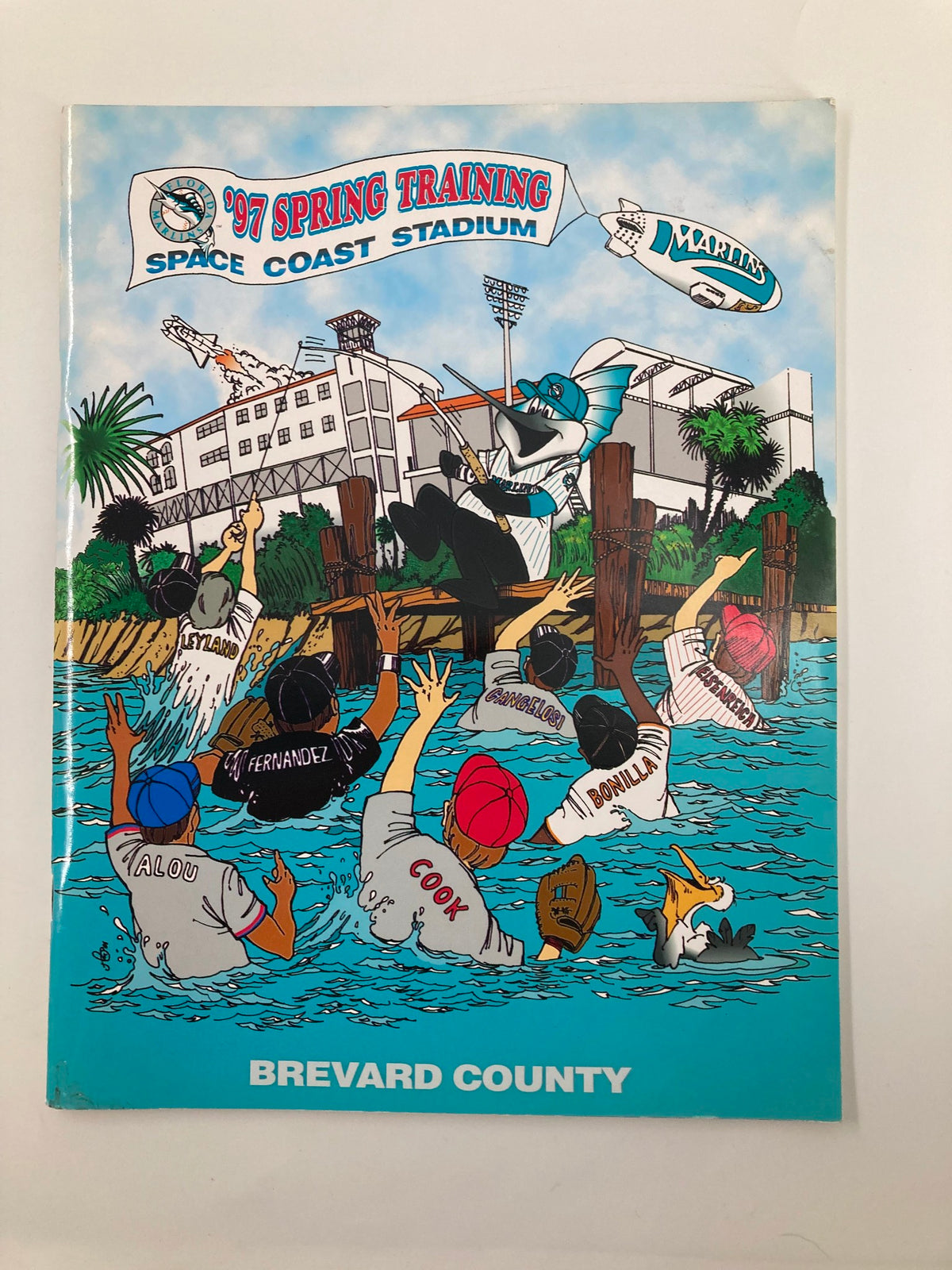 Cover of the 1997 Spring Training Space Coast Stadium Brevard County Program featuring a colorful illustration of players in a pool celebrating.