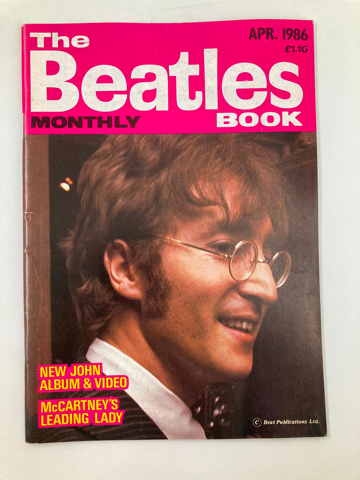 The Beatles Book Monthly Magazine April 1986 #120 featuring John Lennon with a pink cover and headlines about John Lennon’s new album and Paul McCartney.