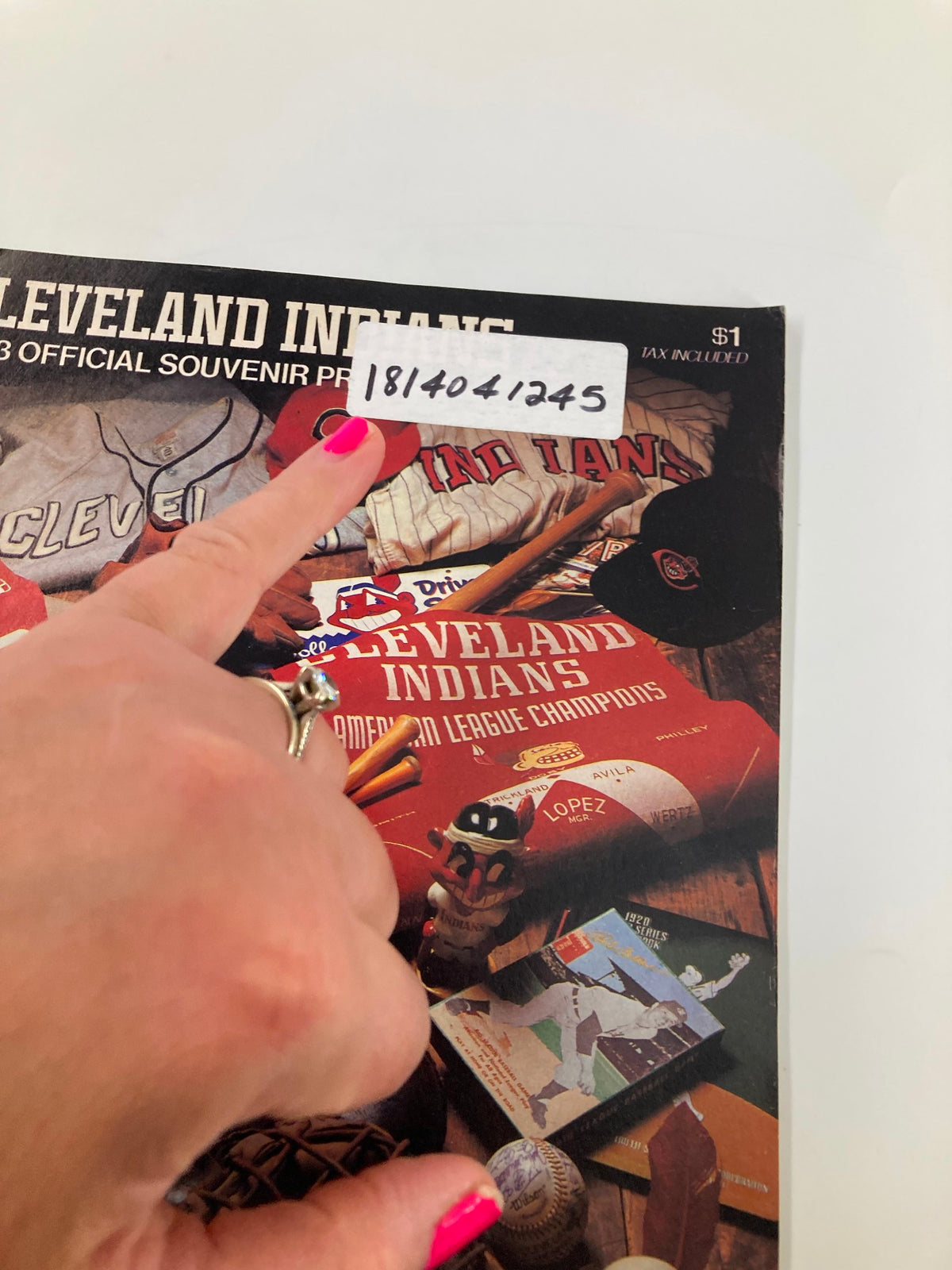 Close-up of the 1983 MLB Cleveland Indians vs Baltimore Orioles Official Souvenir Program cover, highlighting a hand pointing at a price tag and signature.