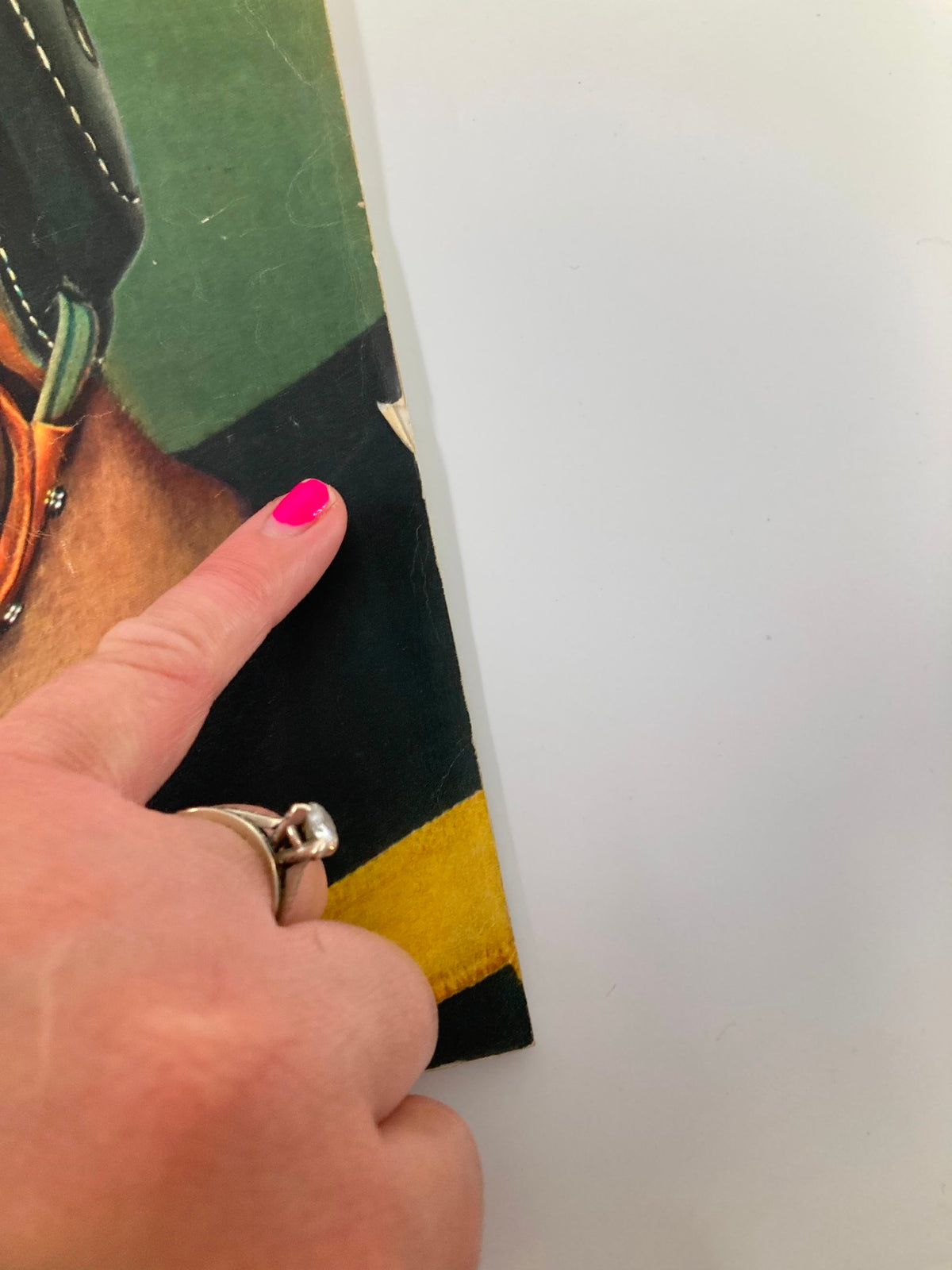 Detail of the VTG Look Magazine November 28 1944 showing a hand pointing at minor wear near the edge of the cover, indicating the magazine's vintage condition.