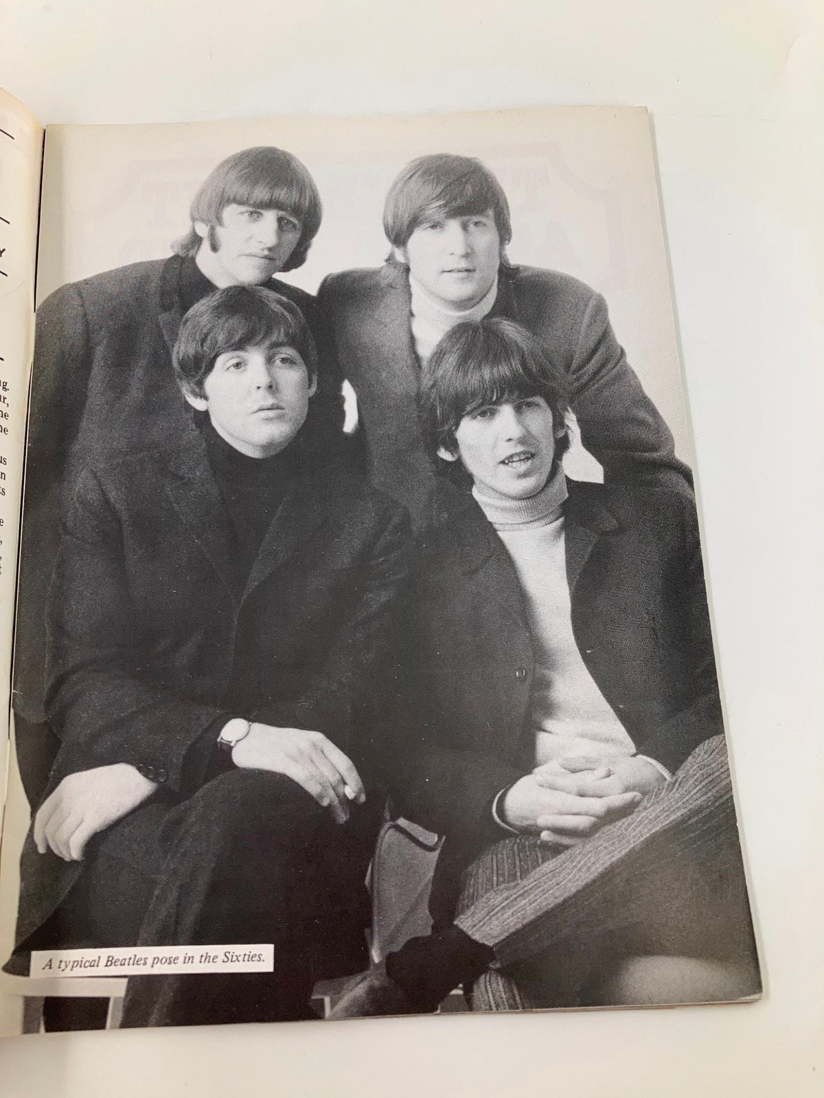 Black and white photography of The Beatles in a typical pose from the 1960s, featured in The Beatles Book Monthly Magazine February 1986, Issue #118. This image captures the iconic group's essence.