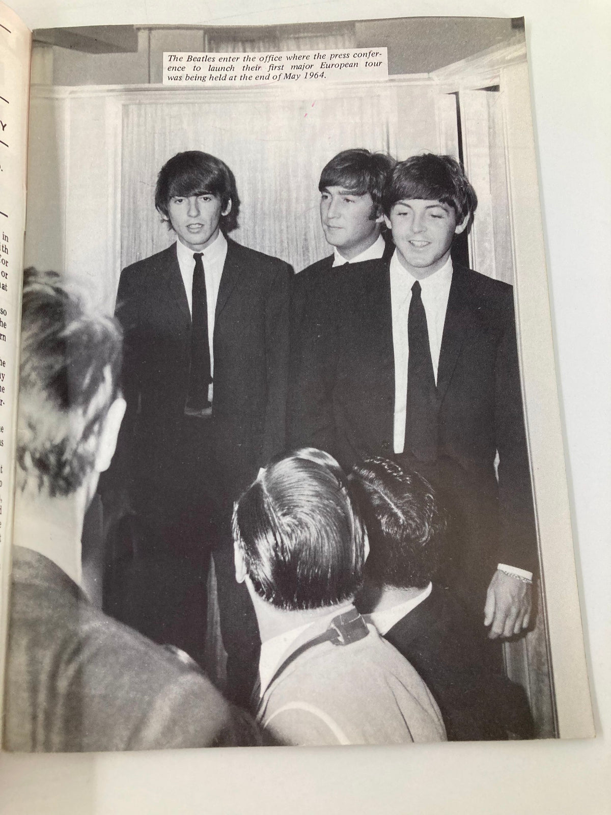 Historic press conference photo from The Beatles Book Monthly Magazine, June 1984, Issue #98 showcasing The Beatles entering the office to launch their first major European tour in May 1964.