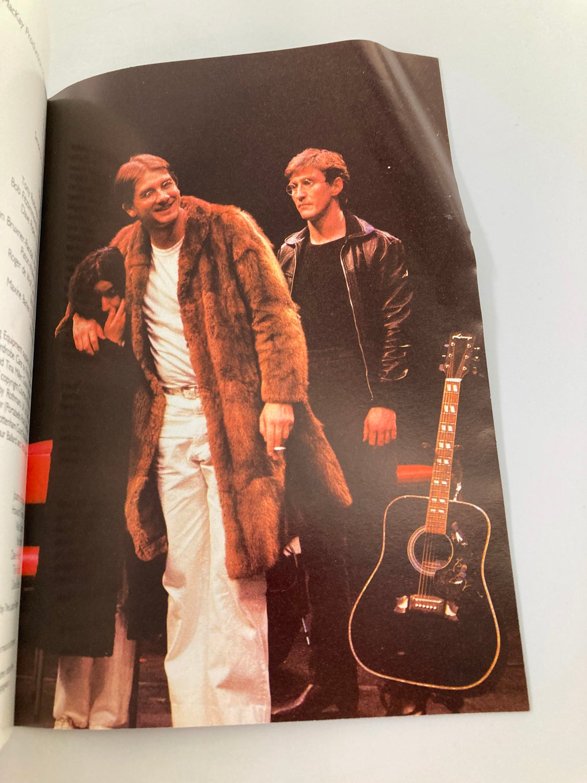 A scene from the 1985 John Lennon at the Astoria Theatre featuring cast members in a dramatic moment, captured by Bob Eaton.
