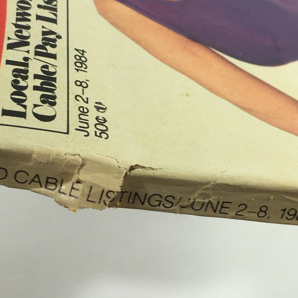 Close-up view of the corner of the VTG TV Guide Magazine June 2-8 1984, highlighting a minor tear and the publication date and pricing.
