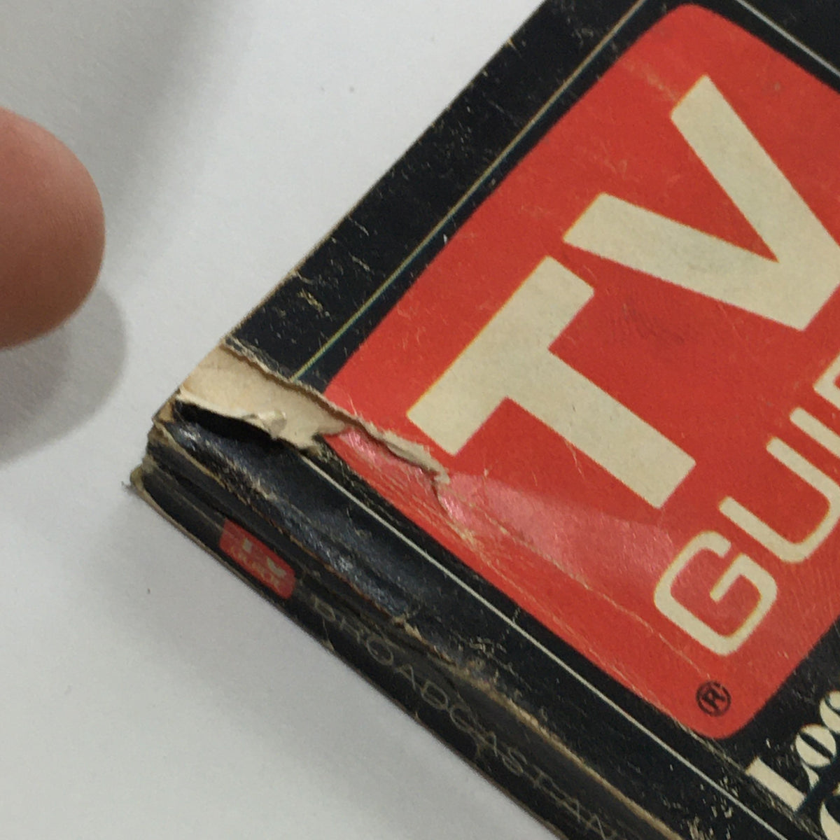 Close-up view of the top corner of the front cover of the VTG TV Guide Magazine April 2-8 1983, displaying wear and tear typical of vintage magazines.