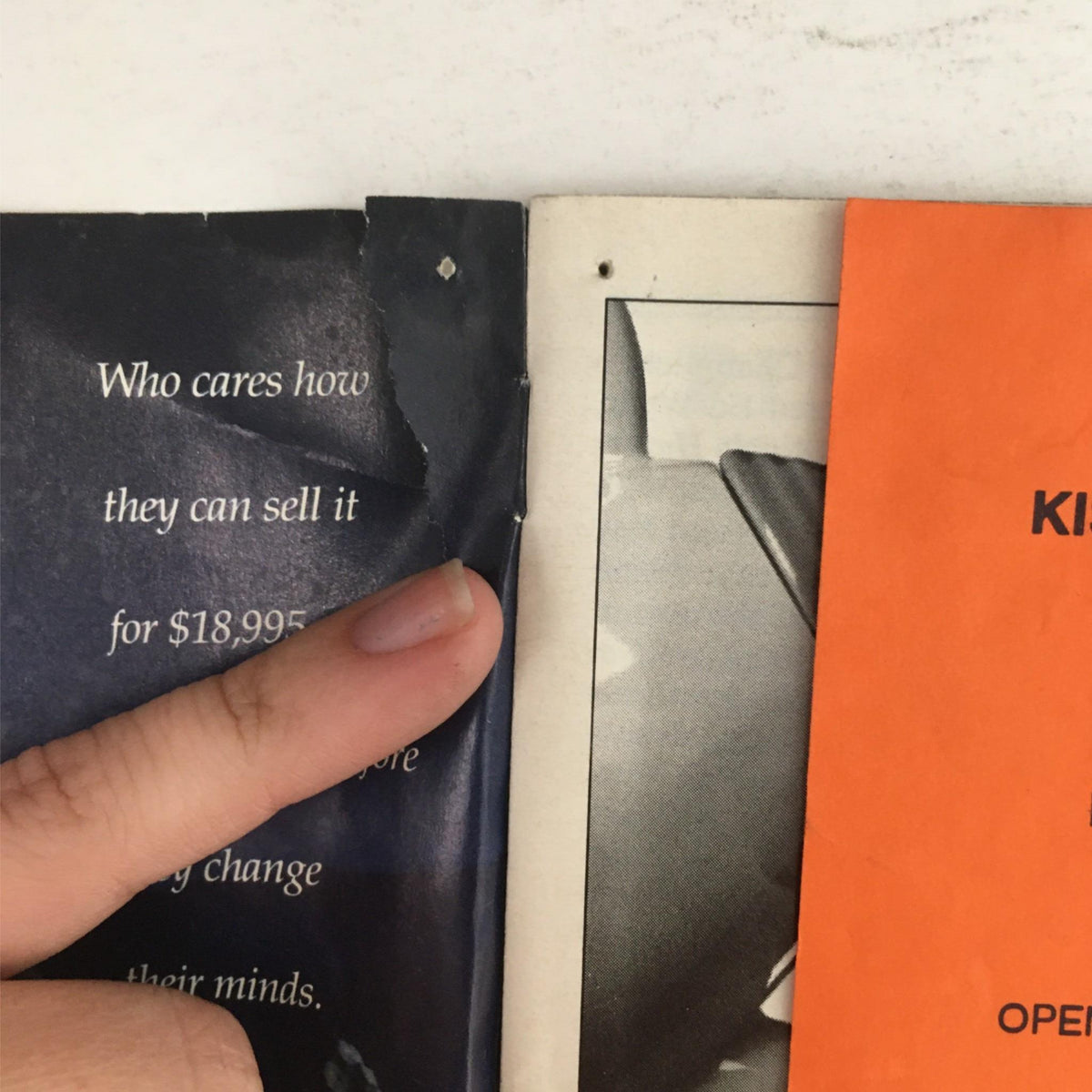 Close-up of a damaged page from the 1993 Playbill for Kiss of the Spider Woman, highlighting the condition of the publication.