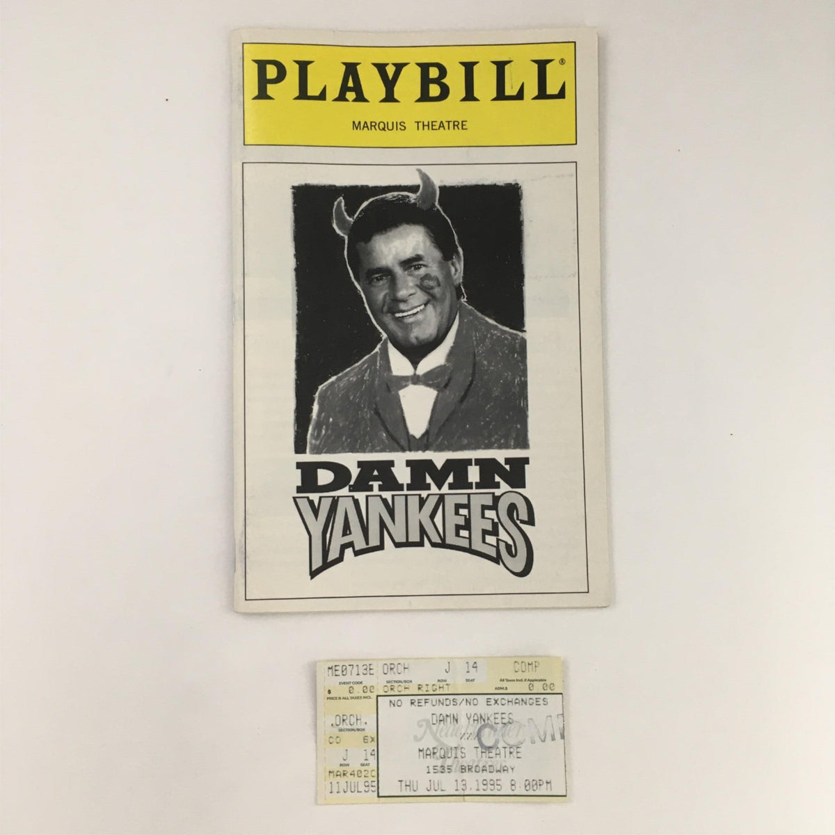 1995 Playbill Damn Yankees by Charlotte d'Ambrose at Marquis Theatre featuring a cover image with a character in a dark suit and devilish horns, alongside an original performance ticket.