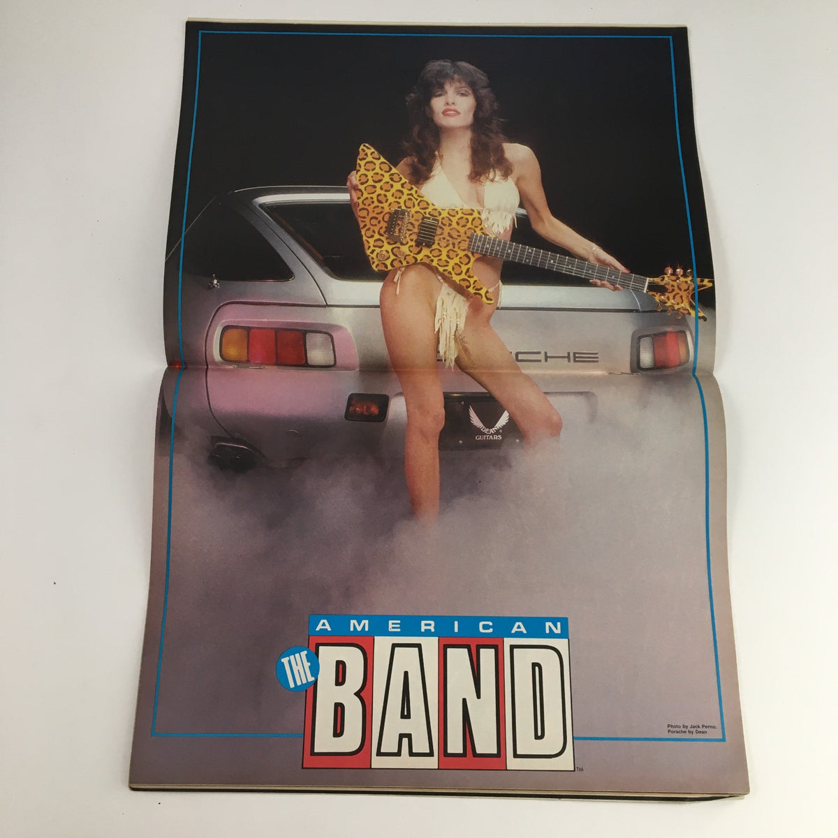 Poster from The American Band Magazine November 1984 featuring a model holding a unique guitar, showcasing the magazine's blend of music culture and lifestyle.
