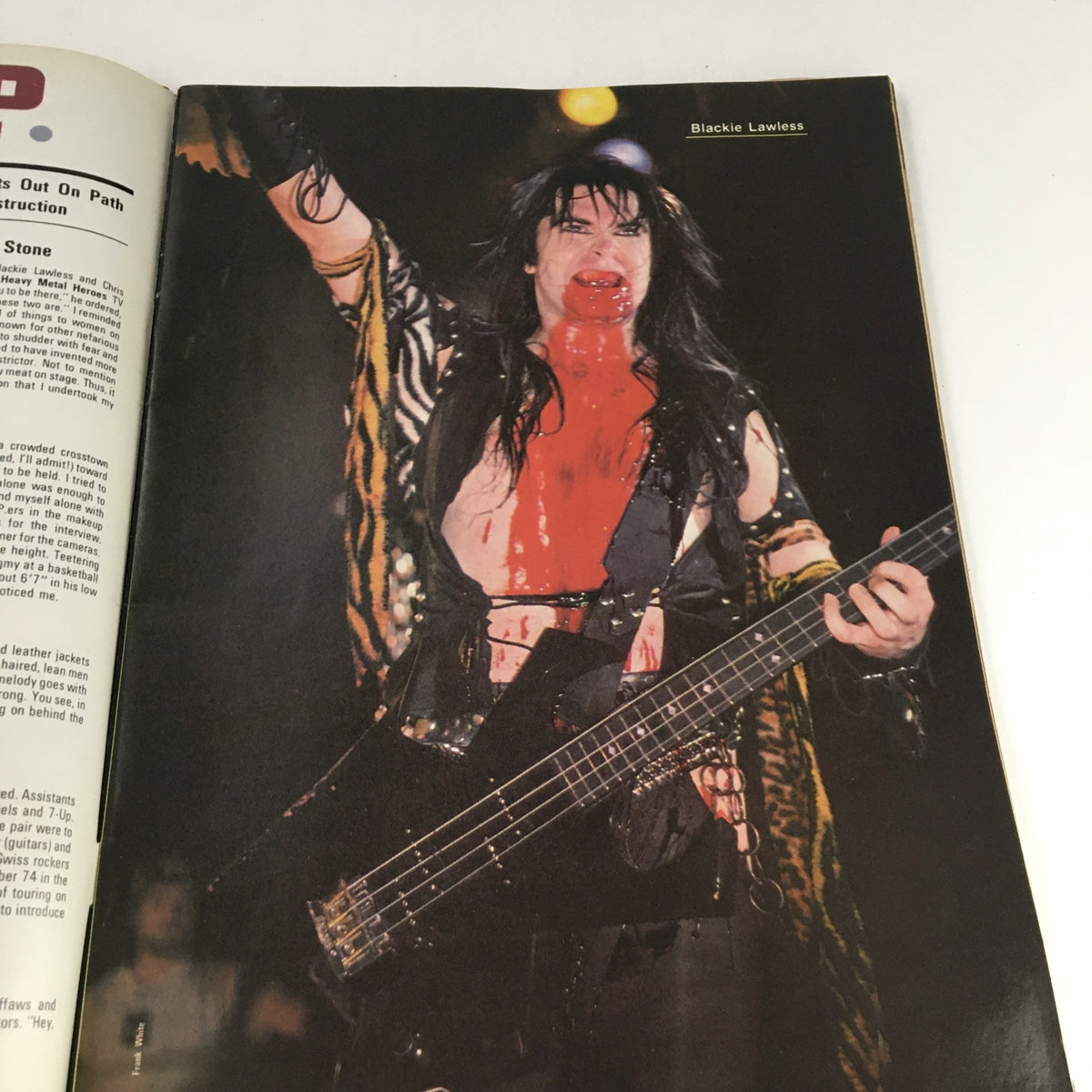 Color image of Blackie Lawless performing on stage, covered in theatrical blood, featured in Hit Parader Yearbook Winter 1986.
