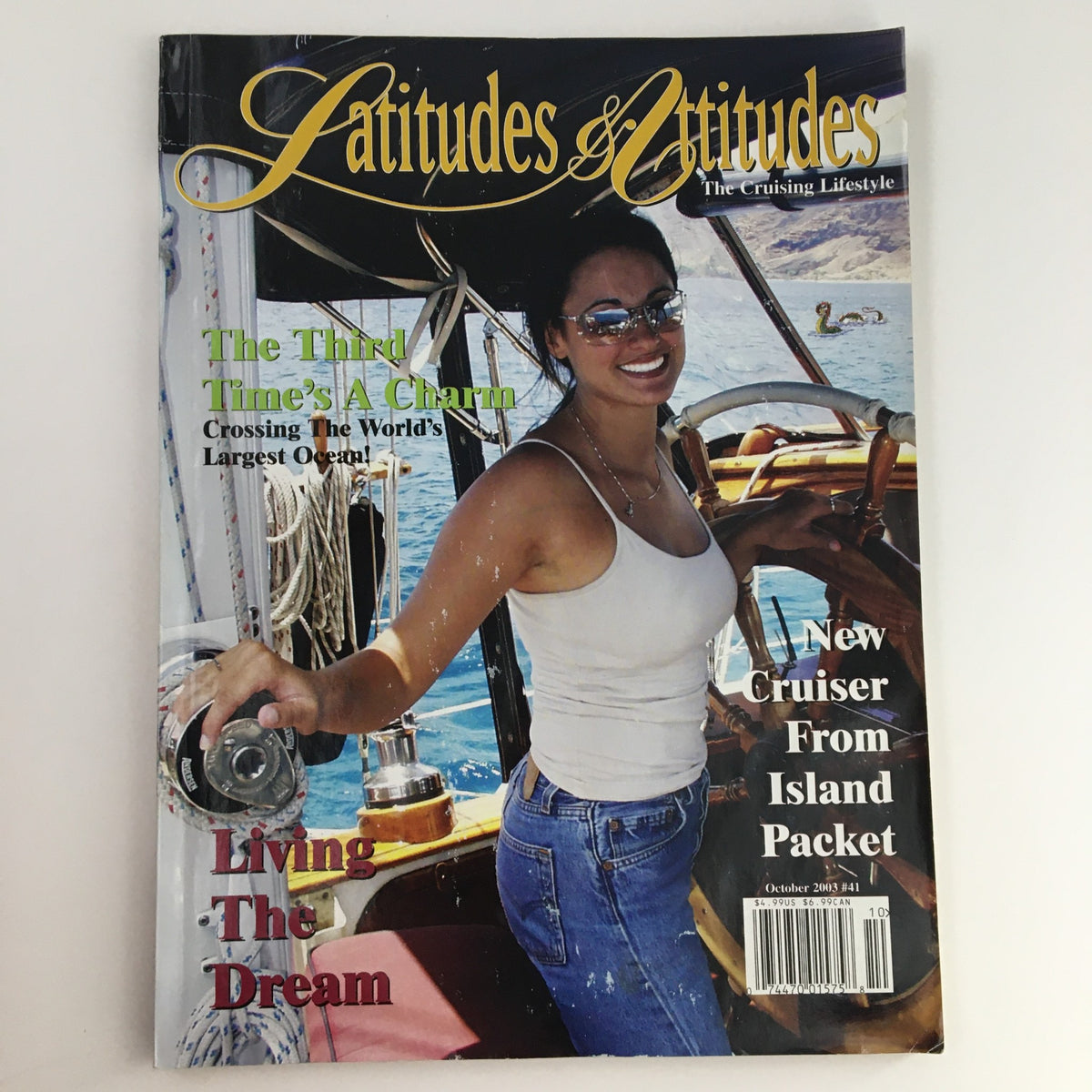 Cover of Latitudes & Attitudes Magazine, October 2003 featuring a woman on a boat, showcasing the theme of cruising lifestyle and highlights a new cruiser from Island Packet.