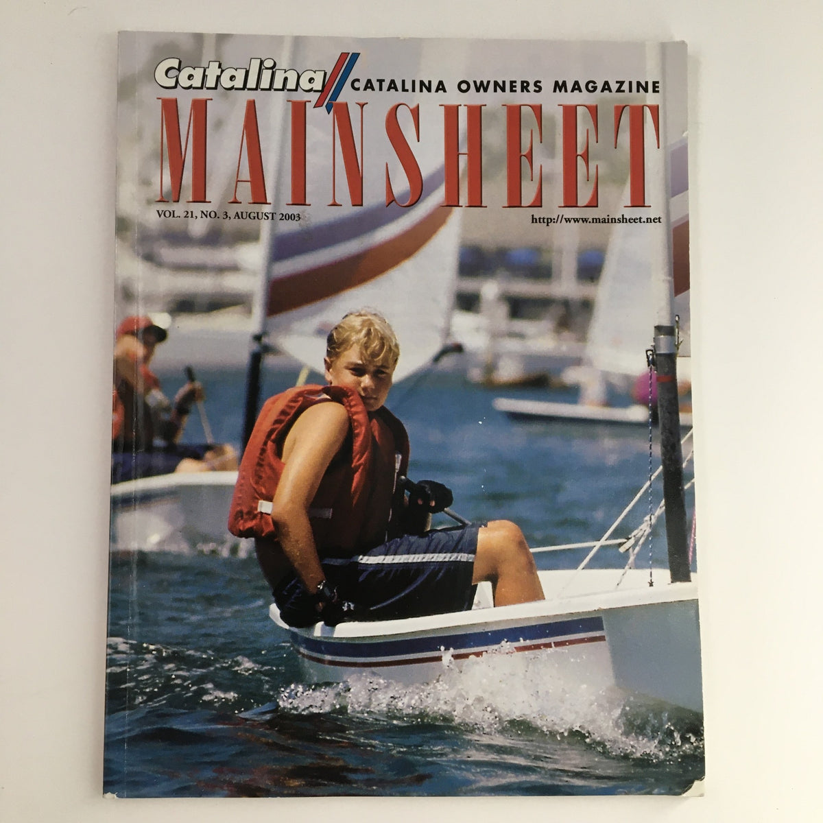 Cover of Mainsheet Magazine August 2003 featuring U.S. Sabot sailing in Marina Del Rey, CA, showcasing a young sailor with a sailboat in the background.