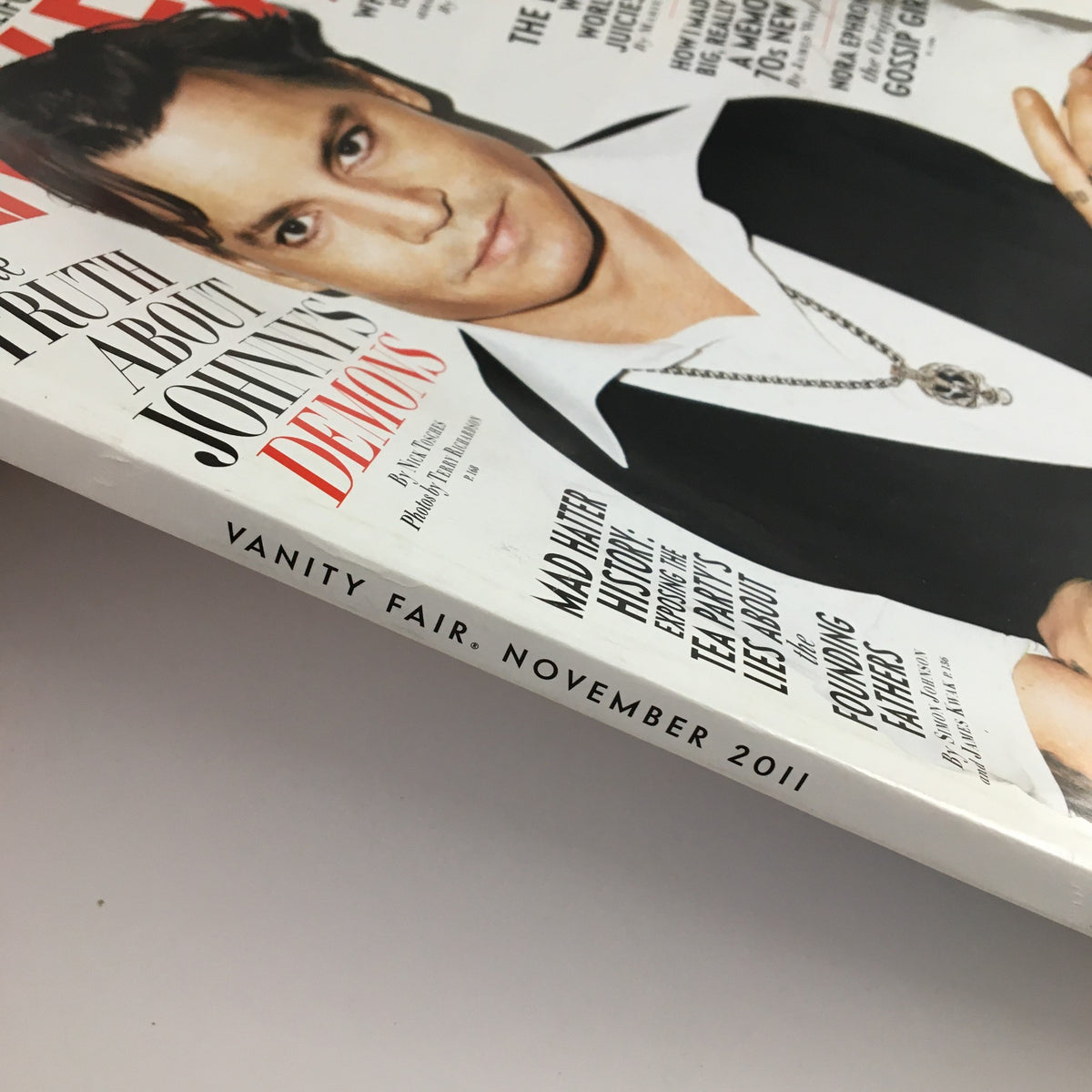 Close-up of the spine of Vanity Fair Magazine November 2011, indicating the issue's title and publication date. Shows details like 'Vanity Fair, November 2011' and the issue's connection to discussions on current events and culture.