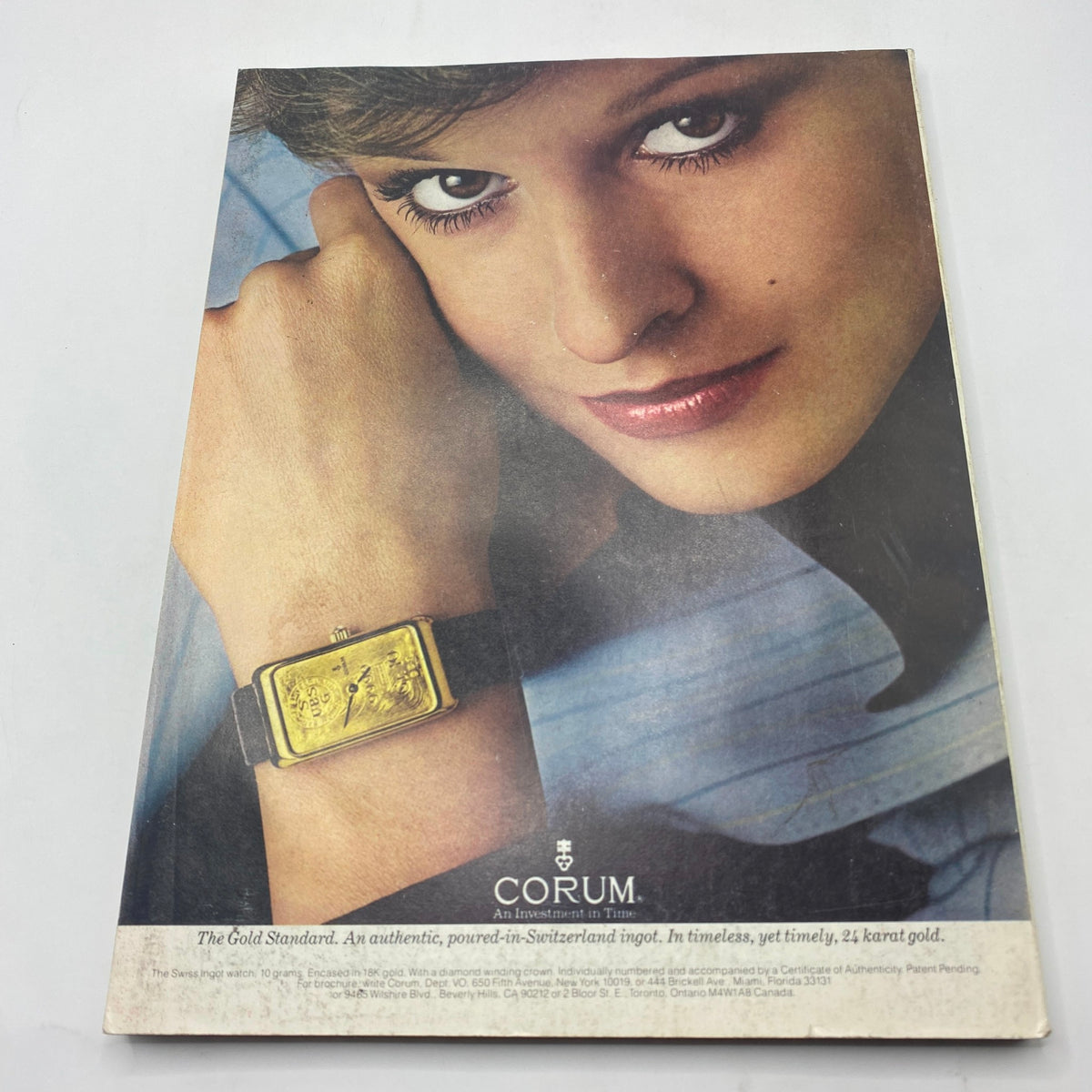 Vogue Magazine August 1980 displaying an advertisement for Corum watches, featuring a close-up of a model showcasing a gold watch on her wrist, highlighting timeless fashion accessories.