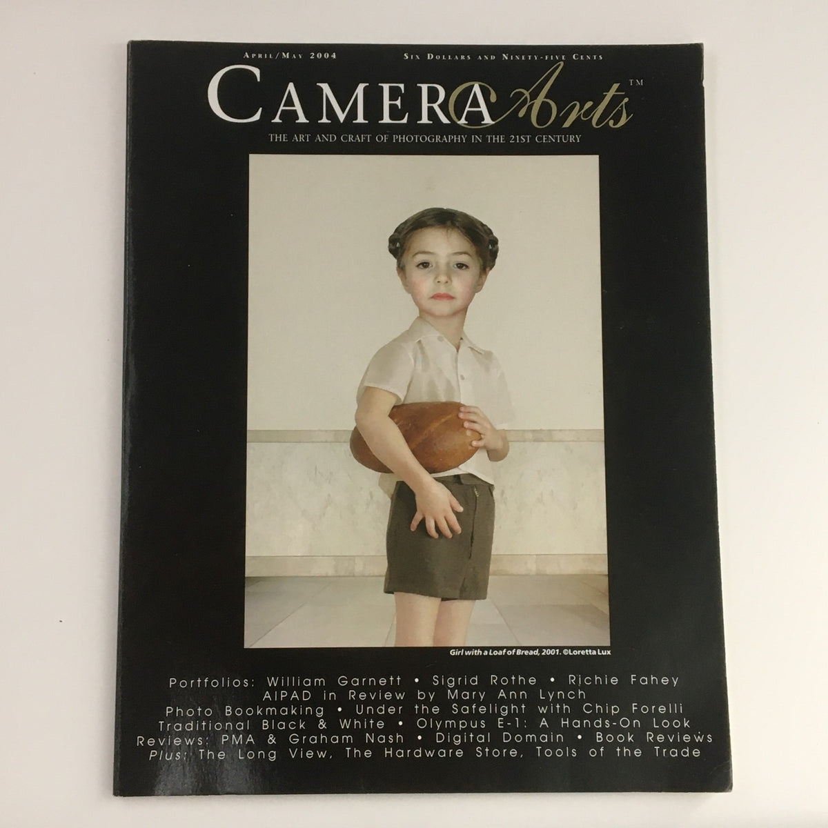 Camera Arts Magazine April 2004 featuring cover art titled 'Girl with a Loaf of Bread' by Loretta Lux. The image showcases the artistic presentation and theme of the magazine.