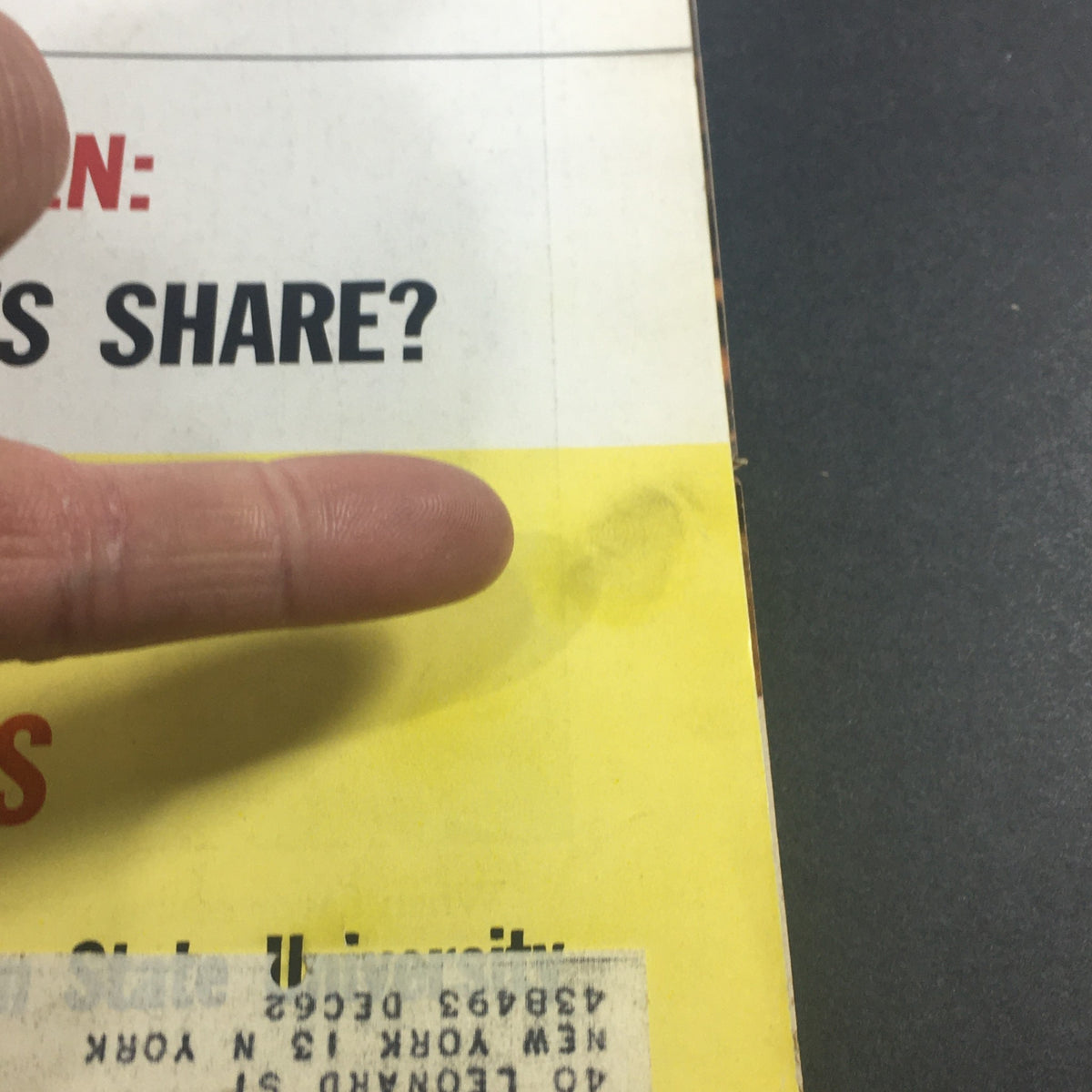 Close-up of the vintage U.S. News & World Report magazine cover from January 21, 1963, highlighting details of wear including a finger pointing to a mark and an address label.
