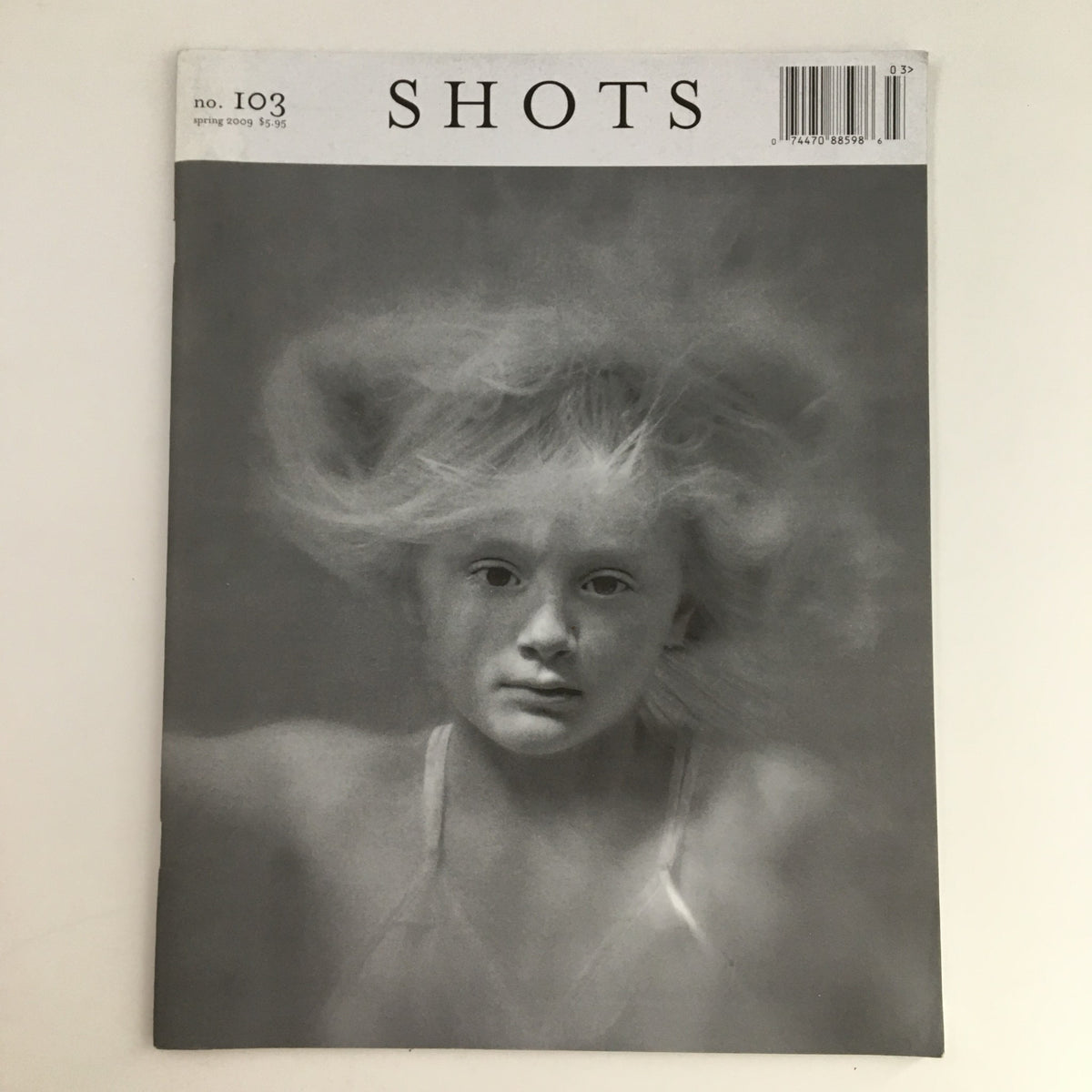 Cover of Inside Shots Magazine Spring 2009 Issue #103 featuring a haunting black and white photograph of a young girl with flowing hair, capturing the essence of artistic photography.