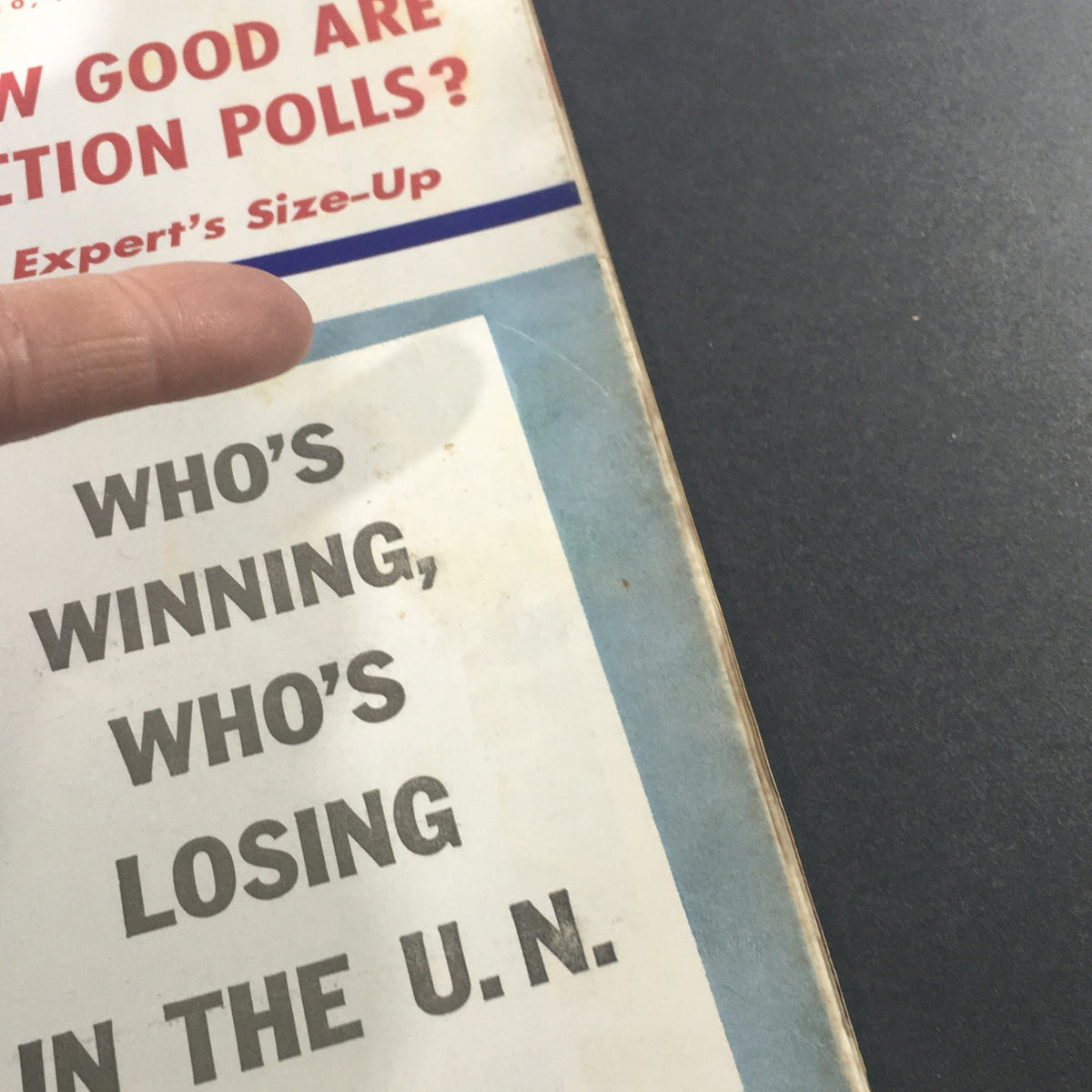 Close-up of the U.S. News & World Report magazine cover from October 10, 1960, highlighting the title 'Who's Winning, Who's Losing In The U.N.' with a finger pointing at it.