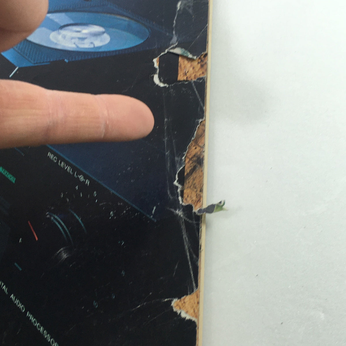 Close-up detail of the cover of VTG Audio and Music Magazine April 1983, showcasing damage with a finger pointing at a tear, highlighting its condition as a vintage collectible.