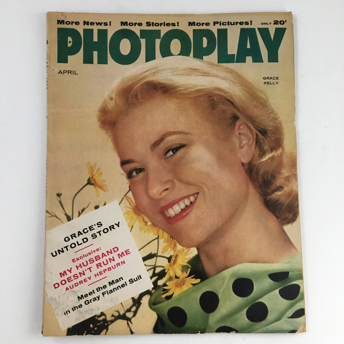 Photoplay Magazine from April 1956 featuring Grace Kelly on the cover. The vintage magazine showcases Grace Kelly smiling amidst yellow flowers, wearing a polka dot outfit. The cover includes titles referencing her untold story and an exclusive interview with Audrey Hepburn.