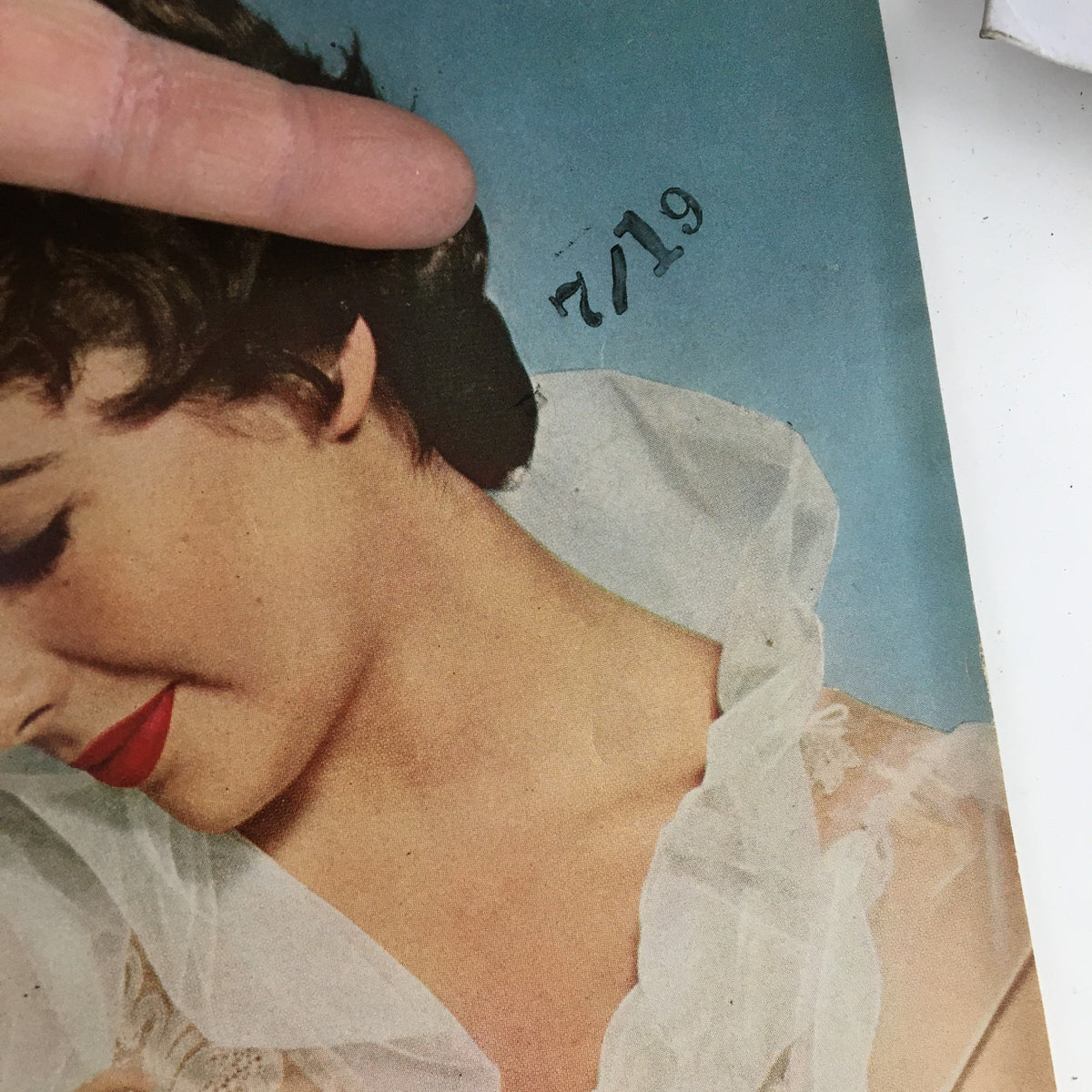 Close-up of vintage Photoplay Magazine cover from August 1955 featuring Elizabeth Taylor, showing her profile with elegant hair and red lipstick, highlighting the magazine's iconic design.
