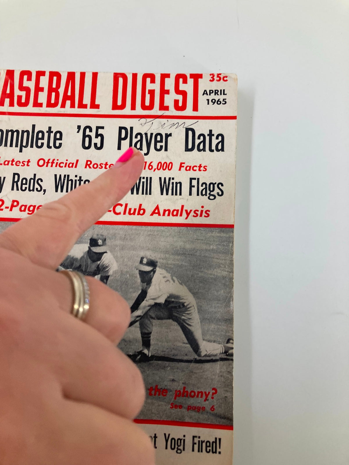 Close-up of the VTG Baseball Digest April 1965 cover indicating 'Complete ’65 Player Data', with a finger pointing at the title and showing its vintage details.