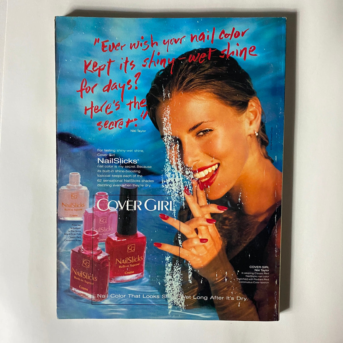 Vogue Magazine August 1994 featuring a vibrant Cover Girl advertisement for NailSlicks nail polish with model Niki Taylor displaying shiny red nails, illustrating beauty trends of the era.