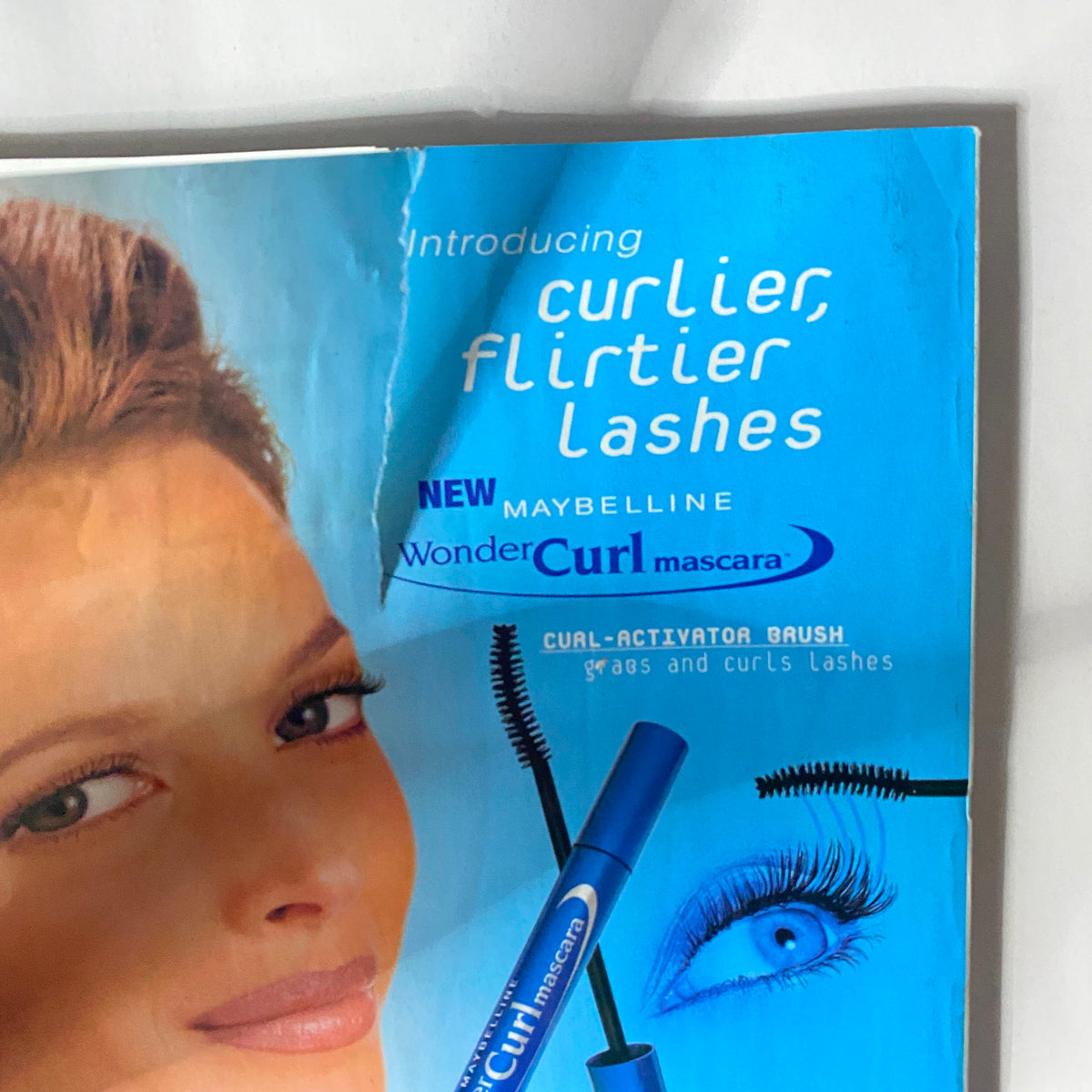 Vogue Magazine January 1999, close-up of Maybelline's WonderCurl mascara advertising, featuring a model's eye with emphasis on the product benefits.