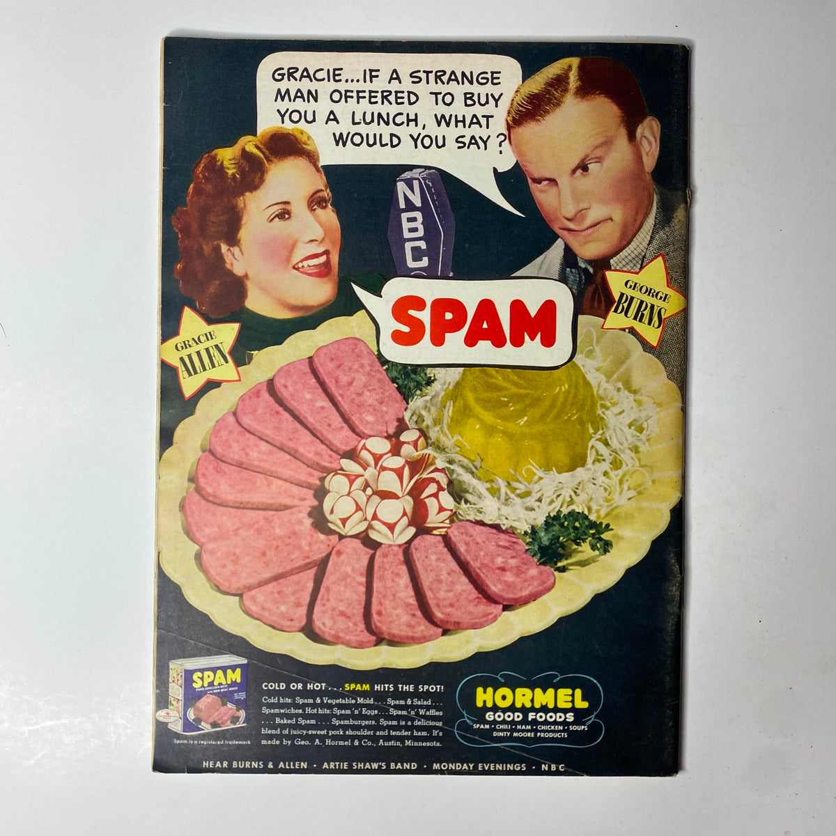 Vintage advertisement for Spam featuring Gracie Allen and George Burns. The ad promotes Hormel's Spam with a playful dialogue, showcasing a colorful platter of Spam alongside the product branding.