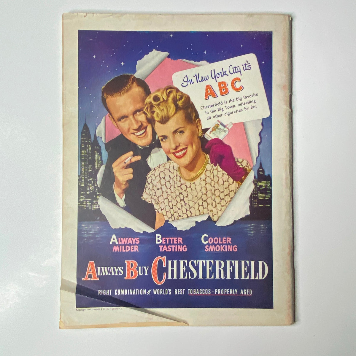 Vintage Chesterfield cigarette advertisement featuring a smiling couple in New York City with the slogan 'Always Buy Chesterfield', promoting the brand's milder and better-tasting tobacco.