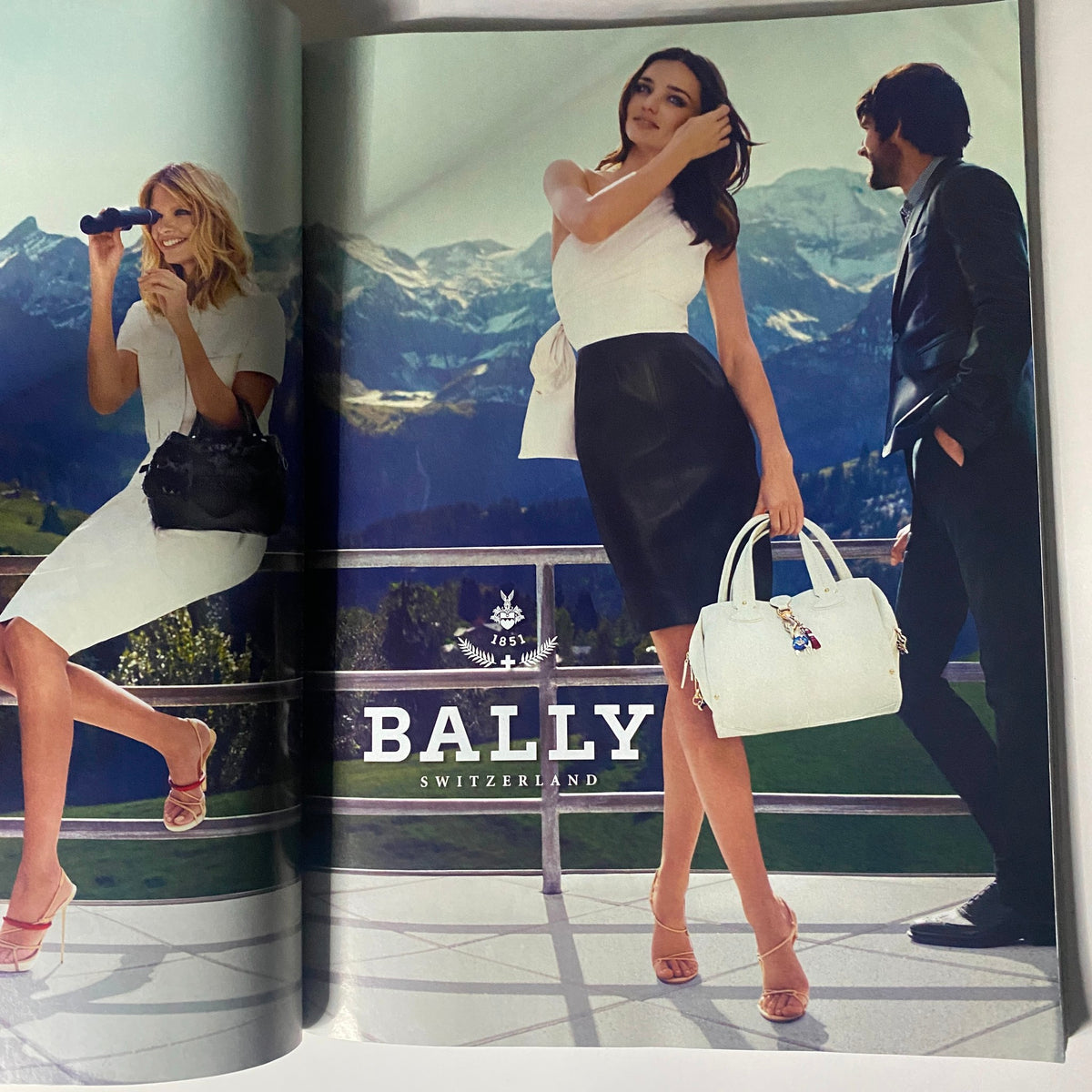BALLY fashion advertisement showcasing elegant models in a picturesque Swiss landscape, featured in Vogue Magazine February 2012 with Taylor Swift by Mario Testino.