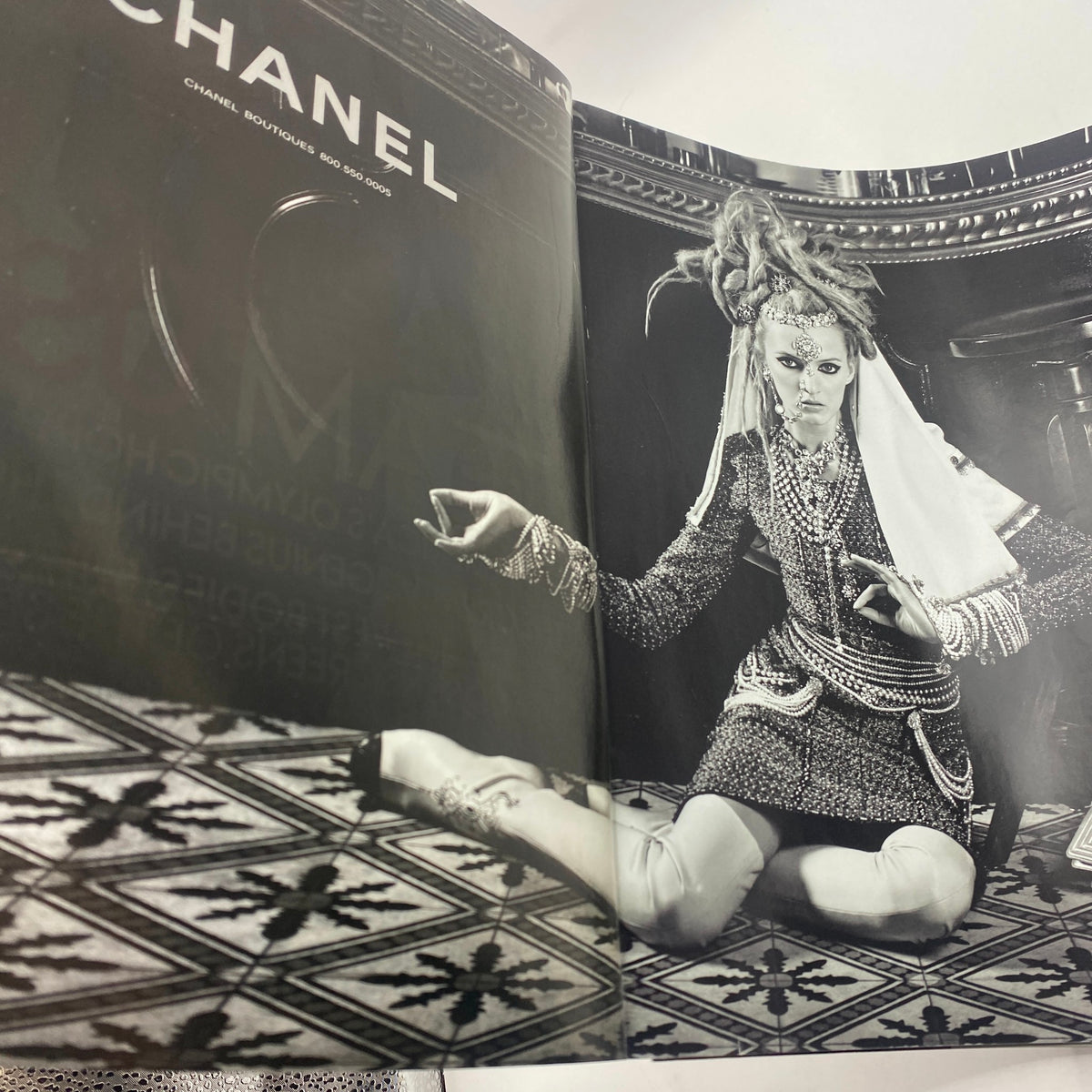 Artistic black and white photograph from Vogue Magazine June 2012 showcasing a model in elaborate Chanel attire, emphasizing high fashion.