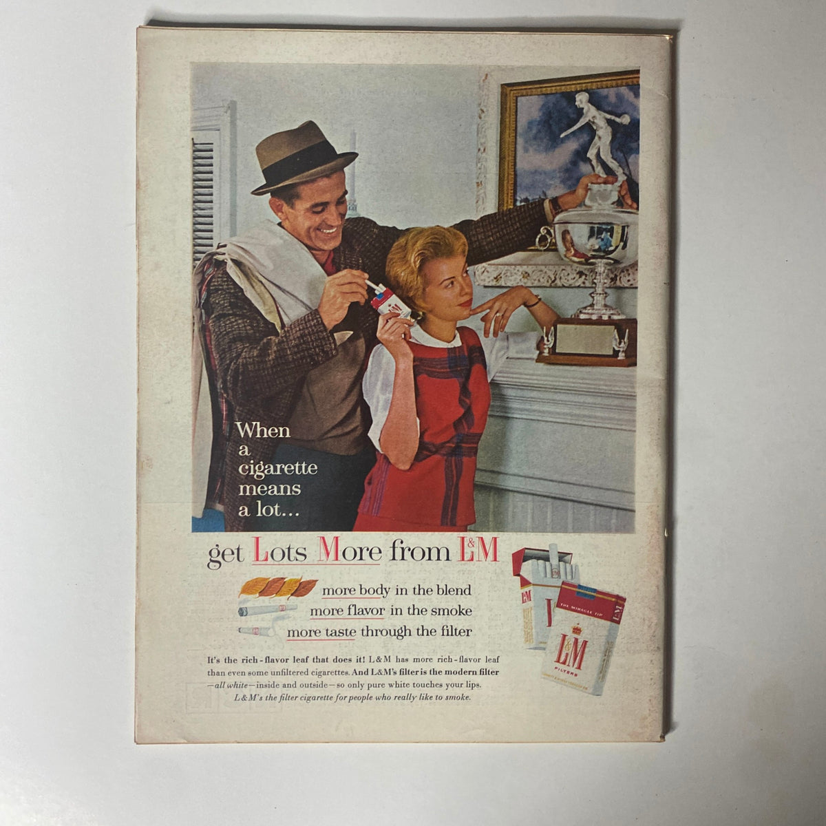 Vintage advertisement from Time Magazine January 11, 1963 for L&M cigarettes, showcasing a man handing a cigarette pack to a woman, promoting the slogan 'get Lots More from L&M' with a focus on taste and flavor.