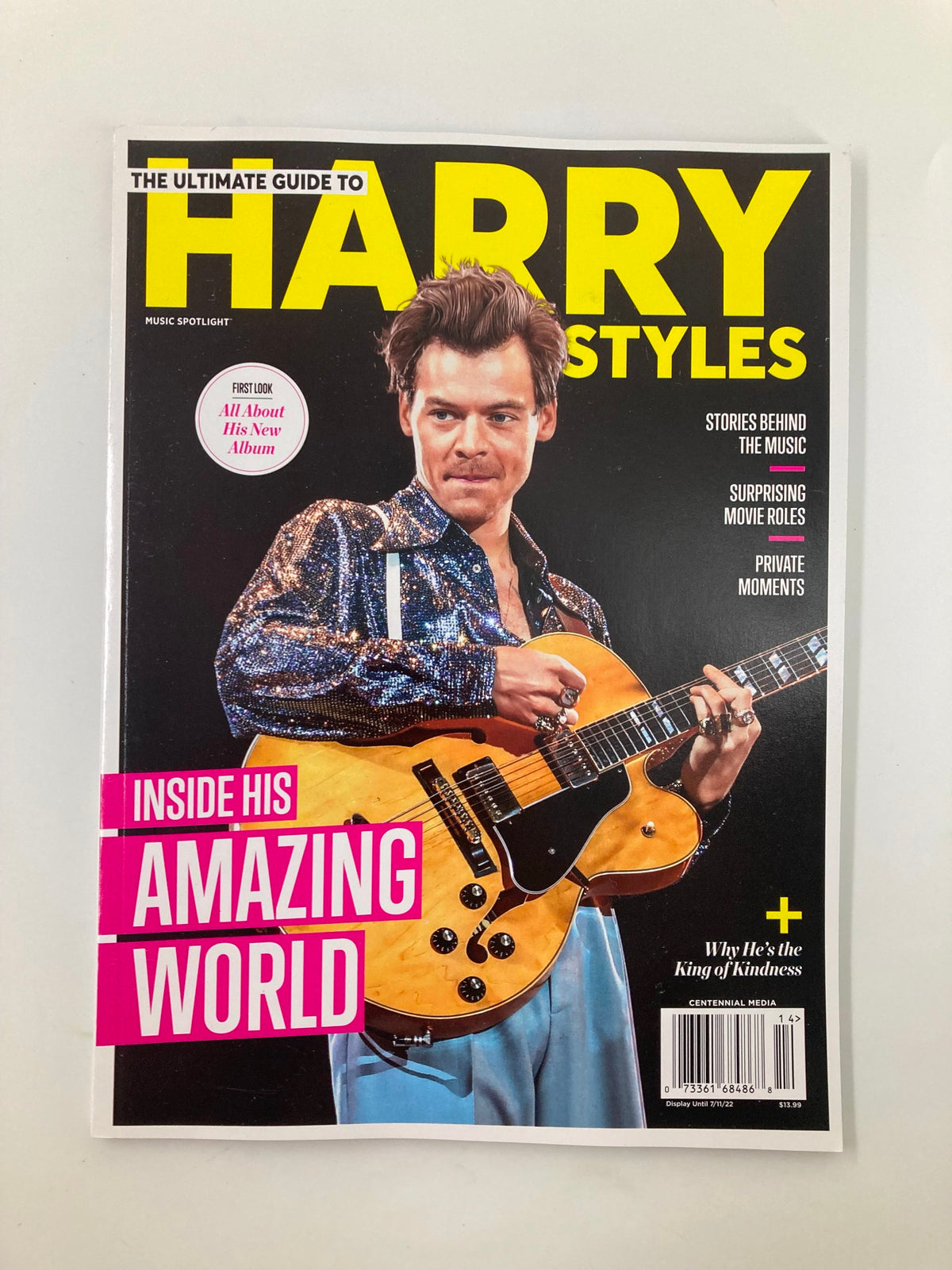 Cover of Music Spotlight Magazine July 2022 featuring the Ultimate Guide to Harry Styles, showcasing Harry Styles holding a guitar in a sparkly outfit, highlighted with the title 'Inside His Amazing World' and additional headlines about stories behind the music.