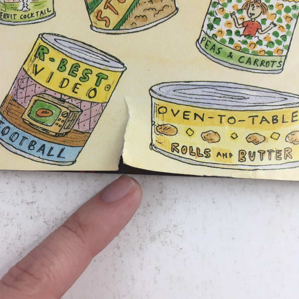 Close-up image focusing on the bottom corner of The New Yorker December 2 1991 magazine cover, highlighting a small rip near the illustrated canned food labels.