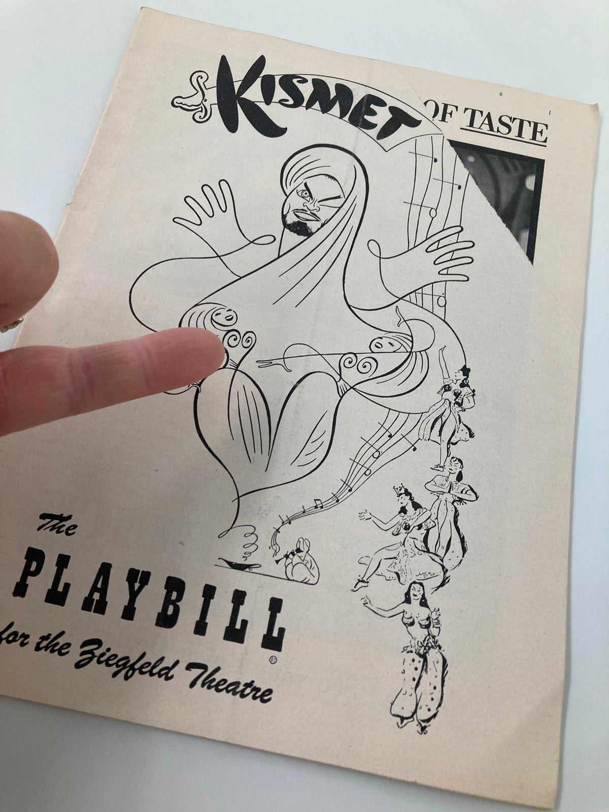 Close-up view of the 1954 Playbill for 'Kismet' at The Ziegfeld Theatre showcasing detailed illustrations and vintage appeal.