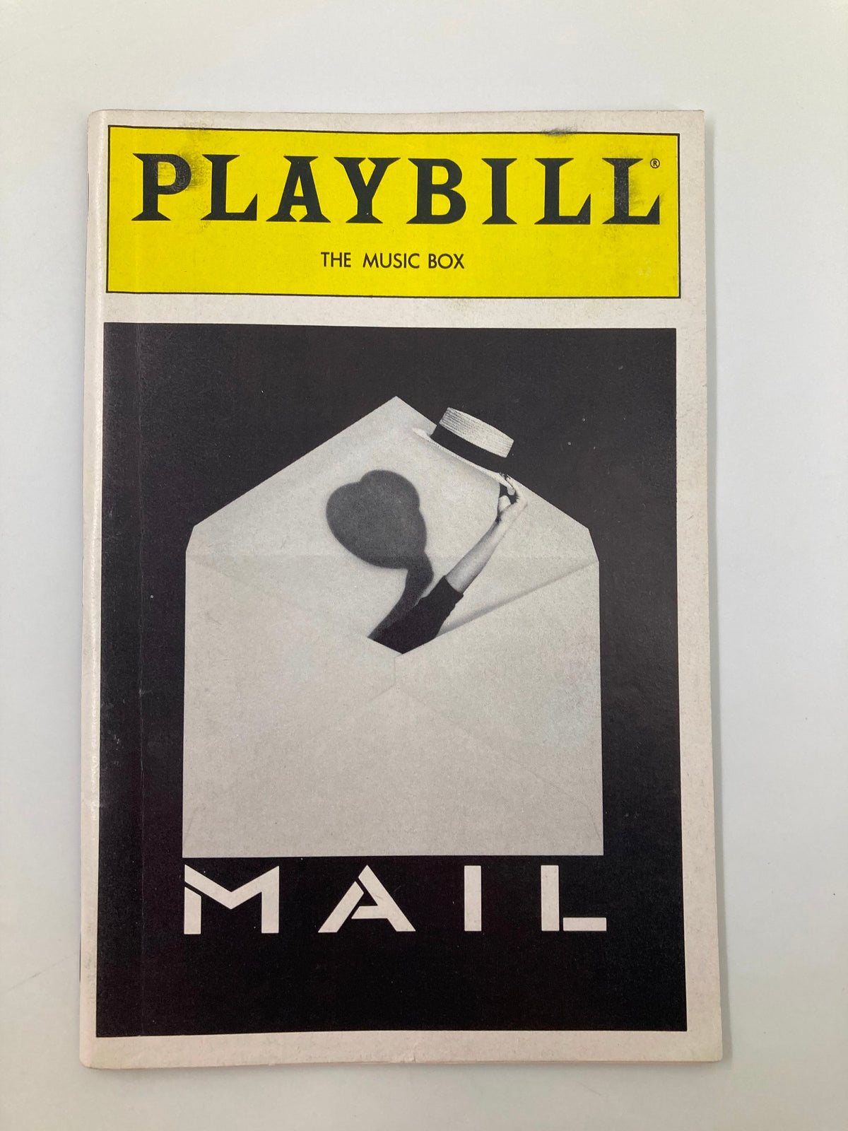 Front cover of the 1988 Playbill for 'The Music Box Mail', featuring a striking black and white design with the title 'MAIL' and a silhouette of a hat-wearing figure.