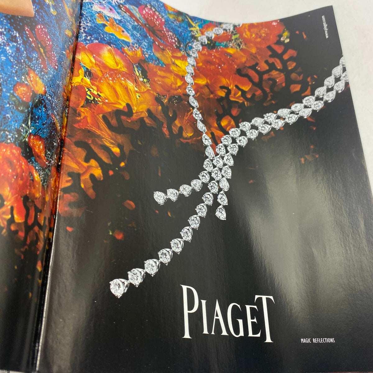 Page from Vogue Paris Supplement December 2005 featuring an elegant Piaget jewelry advertisement with a diamond necklace against a vibrant artistic background.