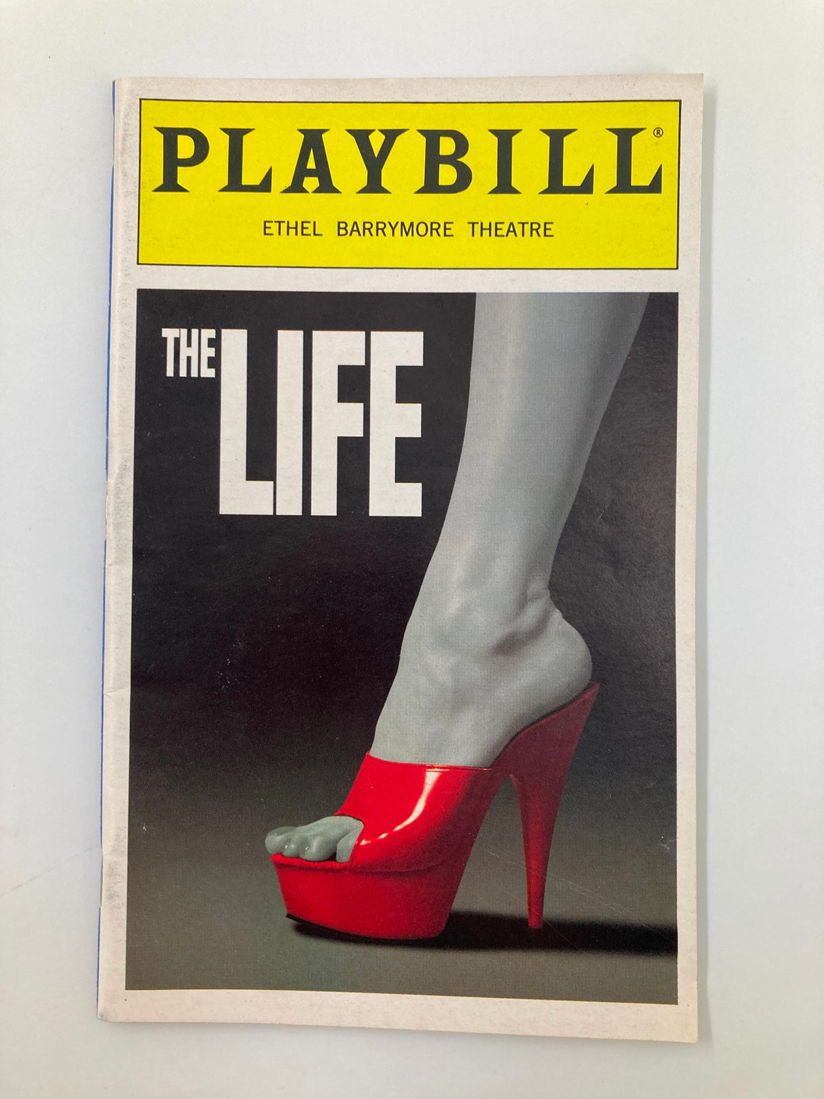 1997 Playbill for The Life at Ethel Barrymore Theatre featuring a striking cover design with a high-heeled red shoe.