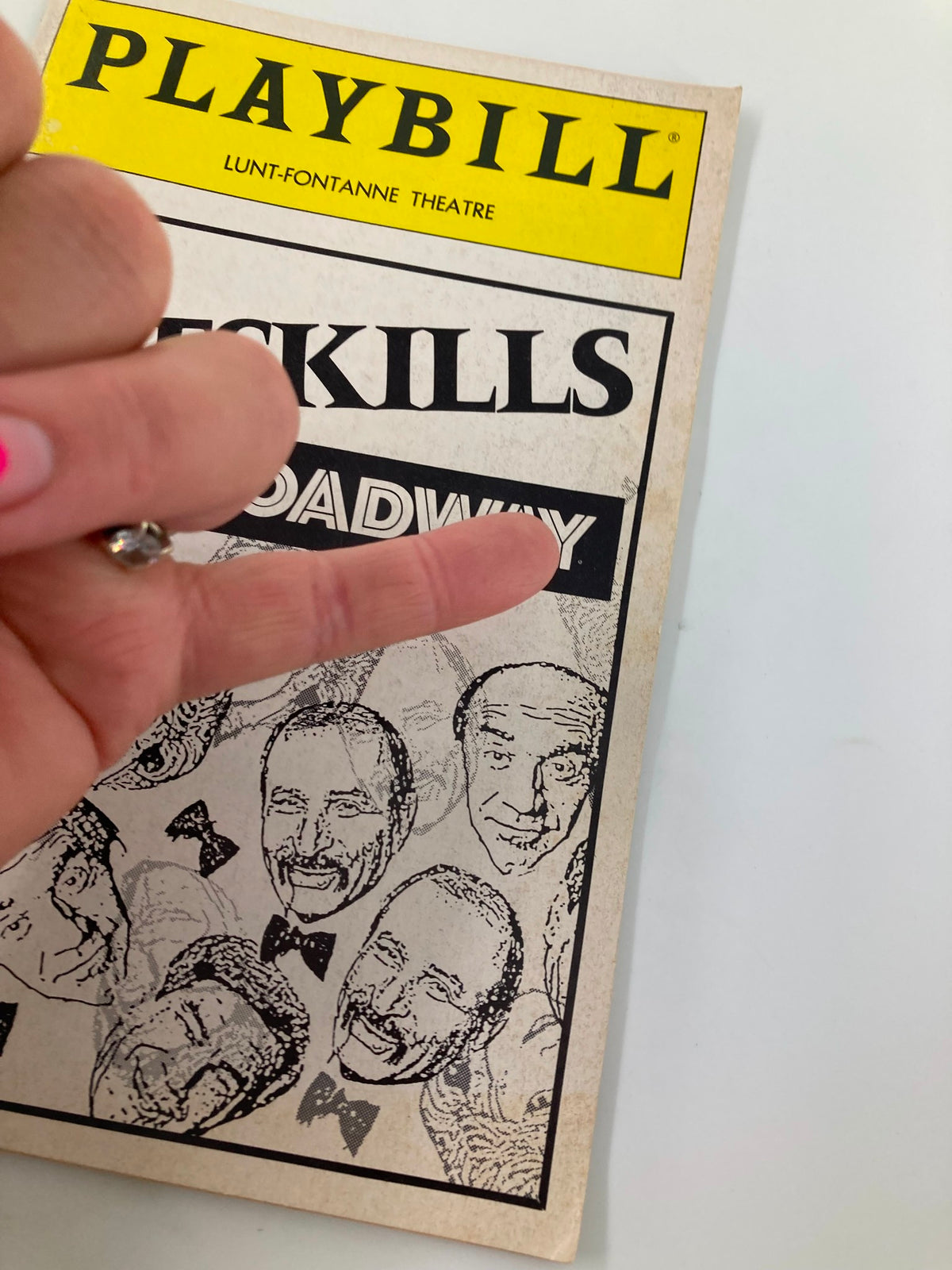 Close-up of the 1992 Playbill Lunt-Fontanne Theatre for Catskills on Broadway, showcasing a hand pointing at the cover's artwork.