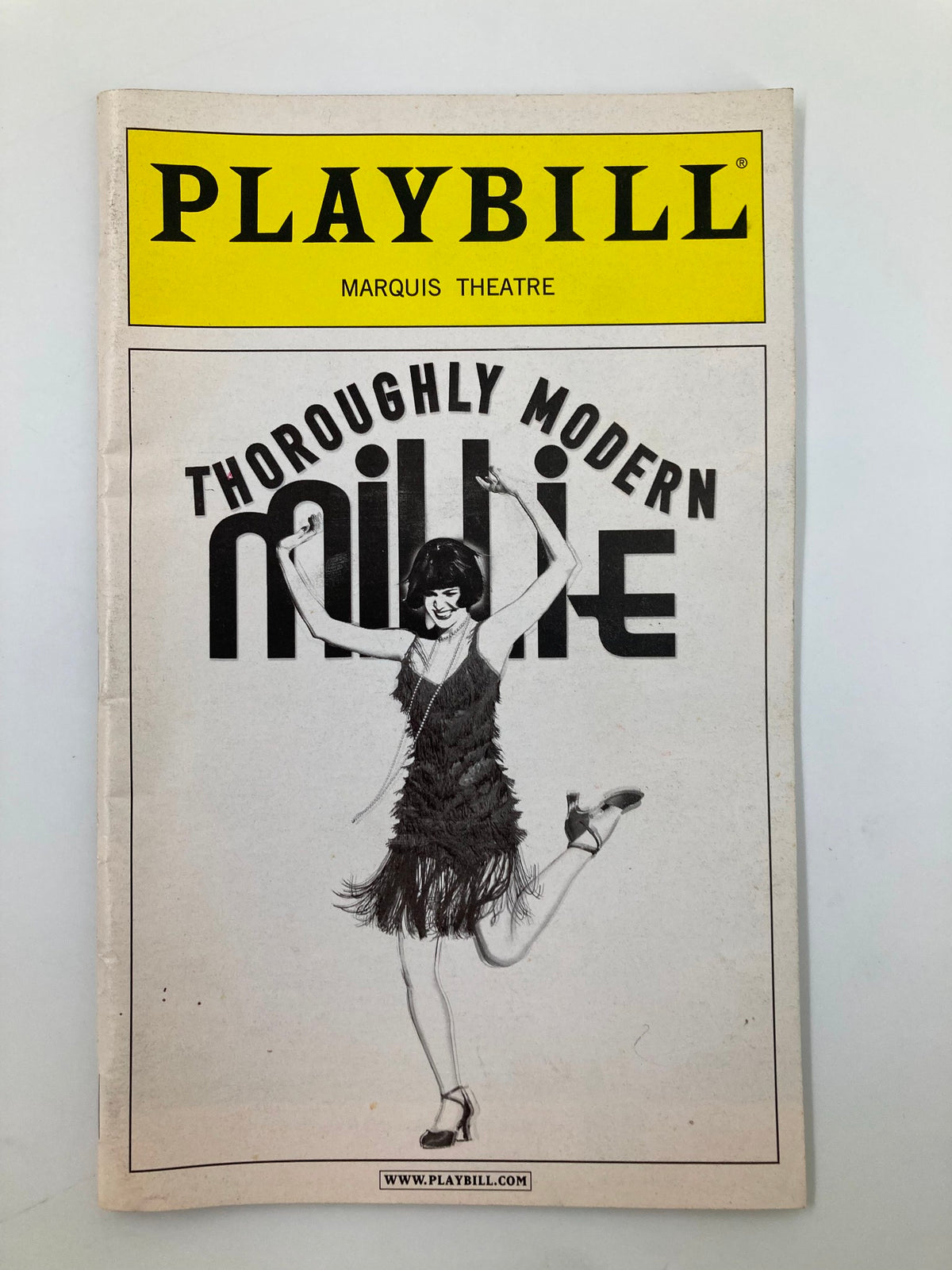 2002 Playbill for Thoroughly Modern Millie at the Marquis Theatre featuring a dancer in a flapper costume.