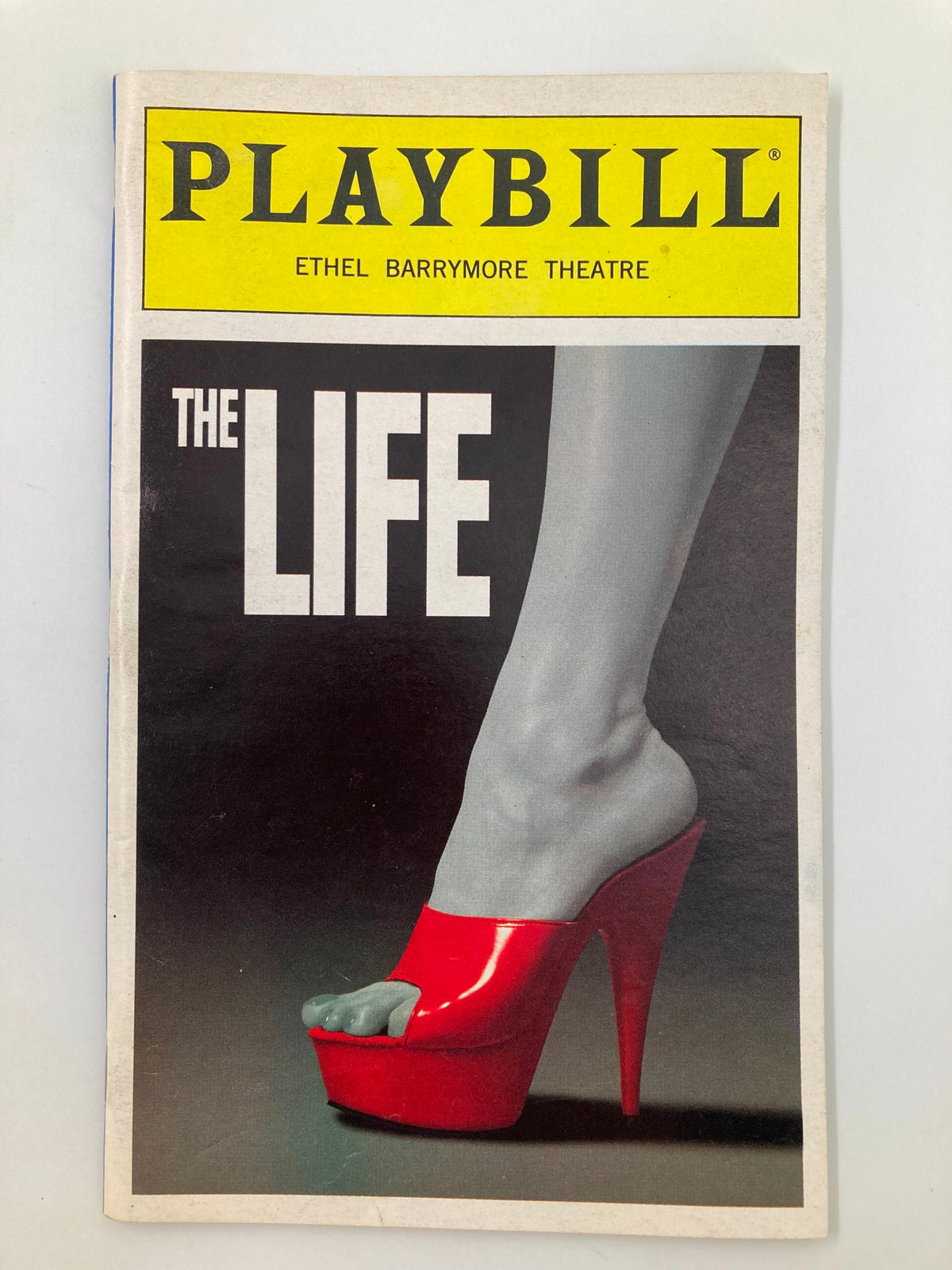 1997 Playbill for The Life The New Musical at Ethel Barrymore Theatre featuring a striking cover design with a high-heeled shoe in red against a black and white backdrop.