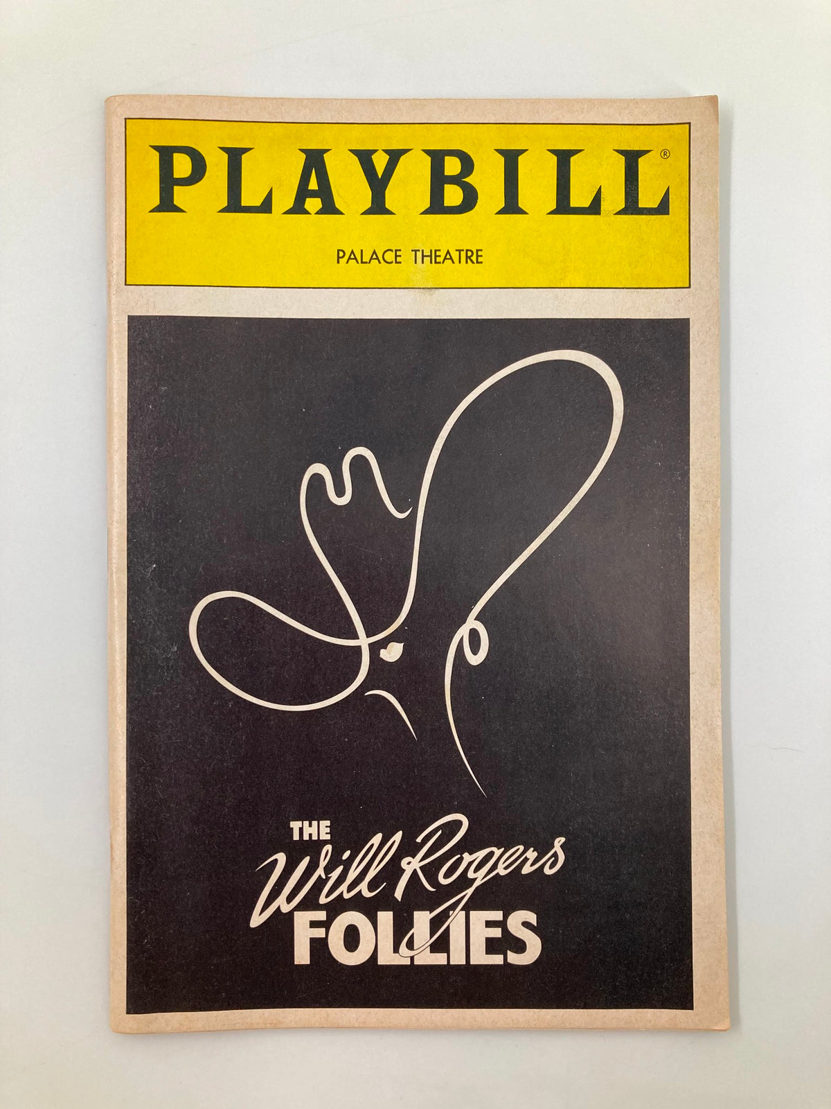 1991 Playbill for The Palace Theatre featuring The Will Rogers Follies, showcasing a minimalist black cover with a white illustration of a cowboy hat and the title in bold letters.