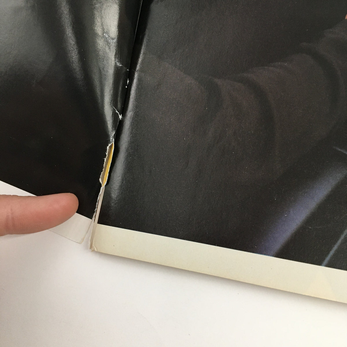 A close-up image showing a small rip and wear at the binding of The New Yorker October 17 1994 magazine, highlighting the magazine's good condition despite minor imperfections.