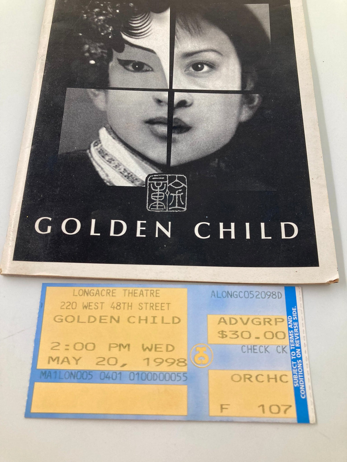 Detailed view of the 1998 Playbill for Golden Child alongside its ticket, highlighting the Longacre Theatre production.