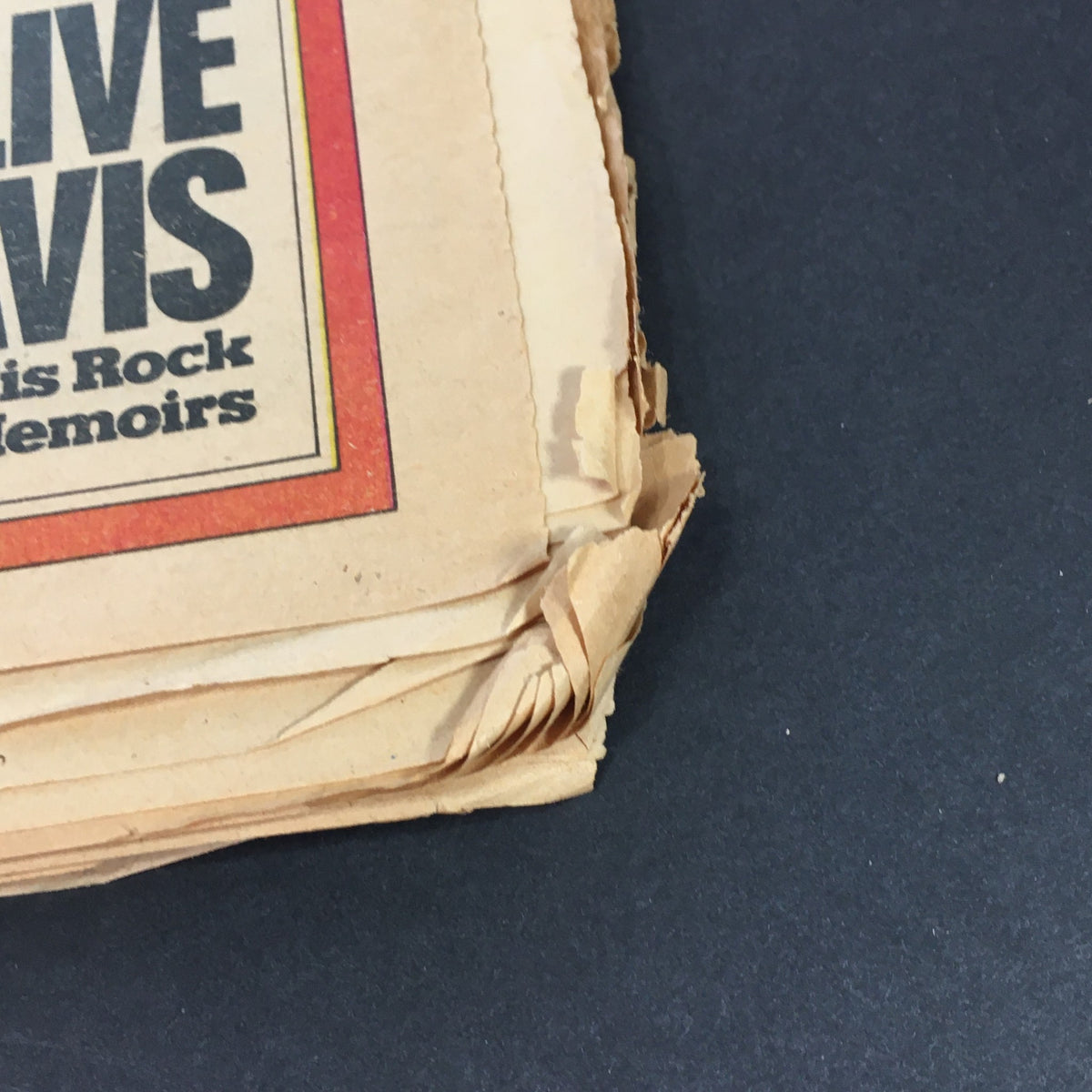 Close-up of the spine of the vintage Rolling Stone magazine from January 2, 1975, focusing on the text regarding Clive Davis's rock memoirs, showcasing the magazine's vintage condition.